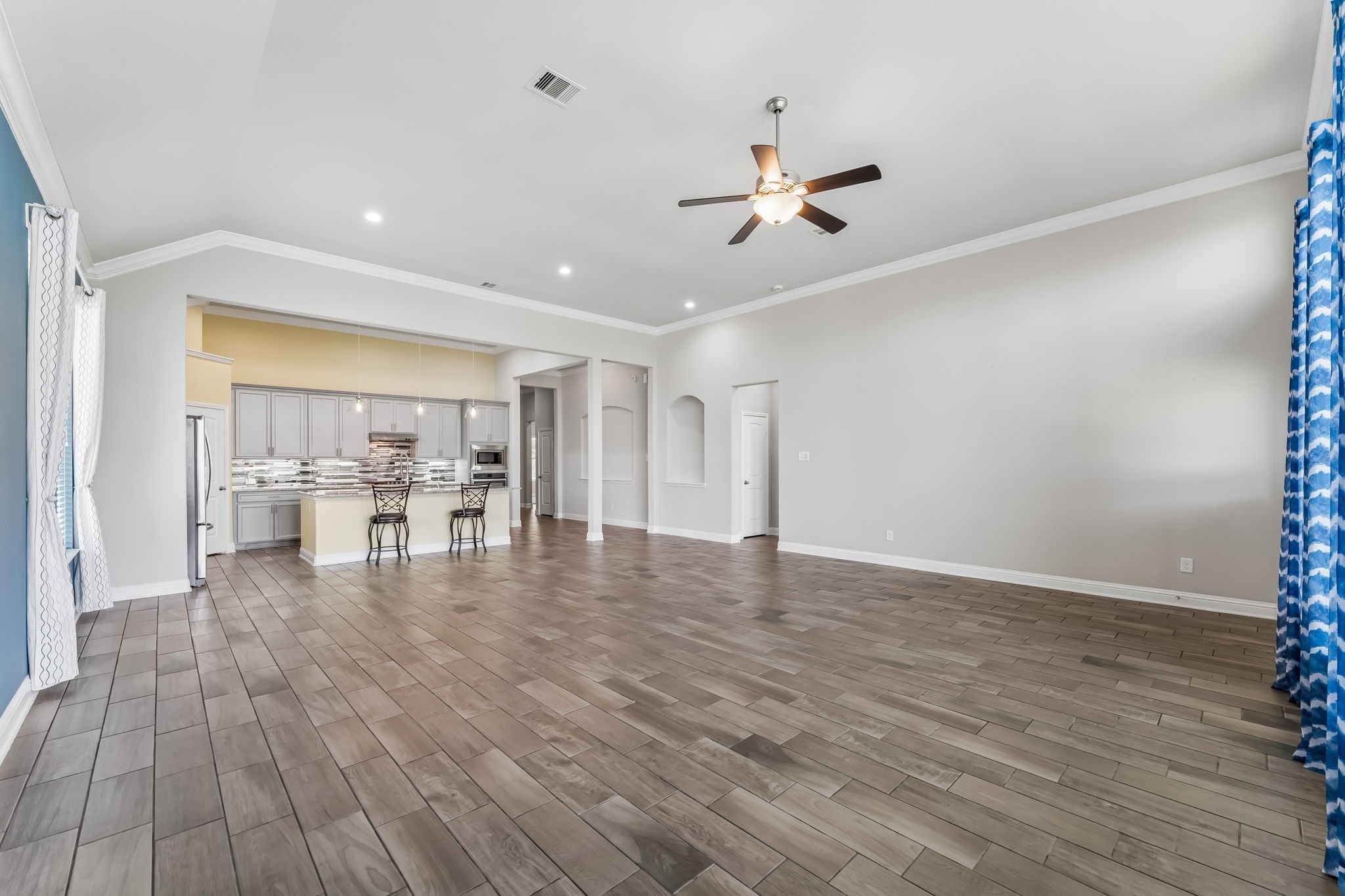 Spacious open-concept living area with high ceilings, modern kitchen, and ample natural light.