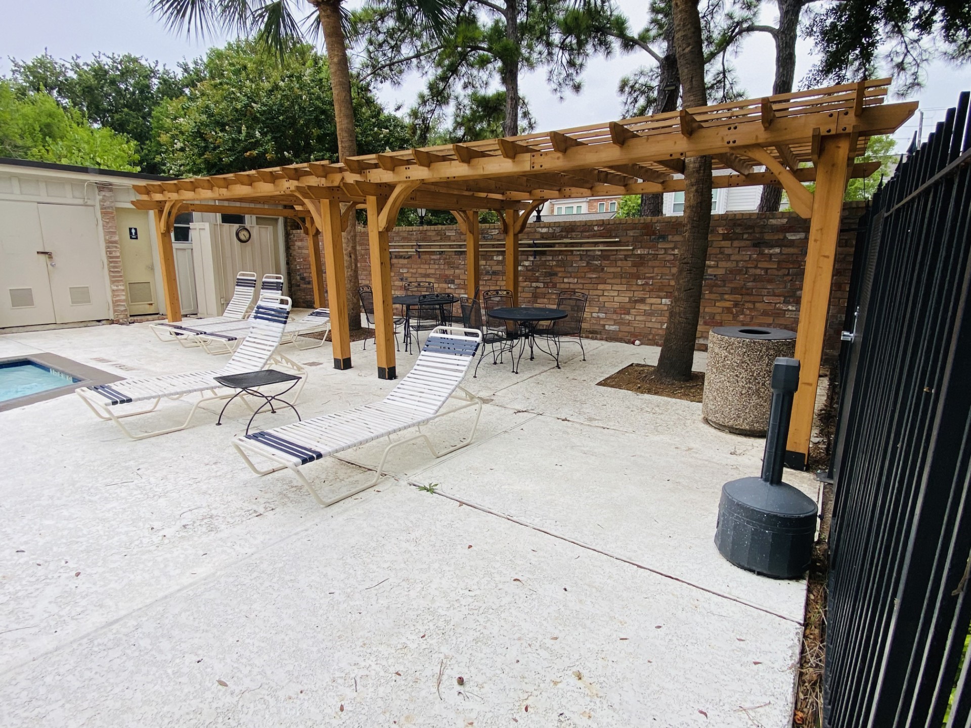 Close up of the new Pergola providing shade to some of the chaise lounge chairs and wrought iron outdoor dining tables and chairs! Note the wonderful "Cool-Crete" decking of the pool! BRING YOUR TOWEL & ENJOY!