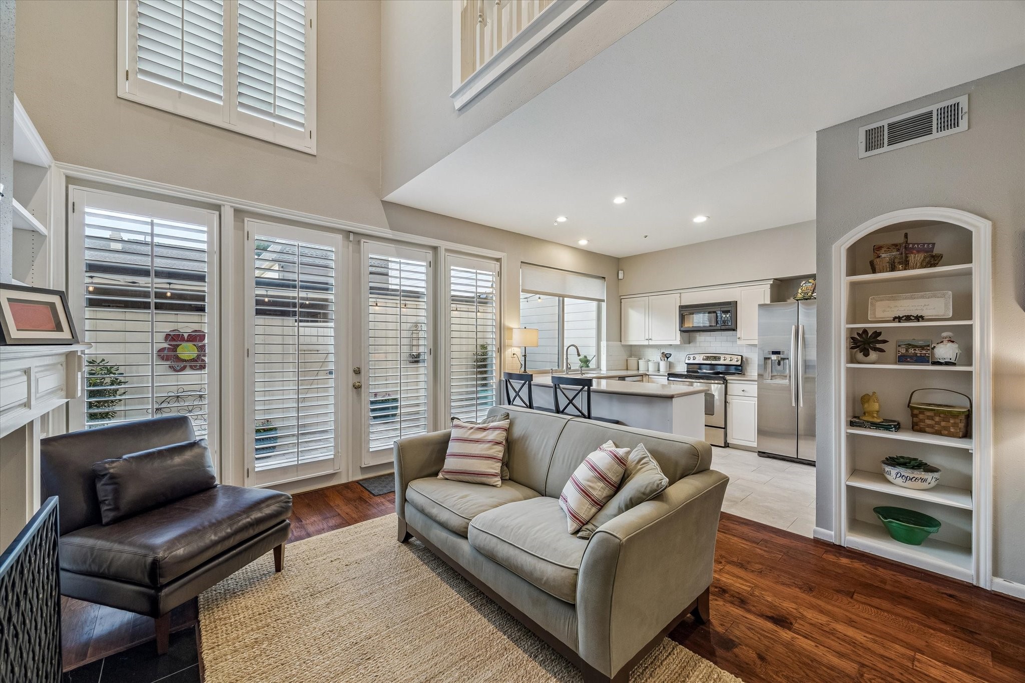The Family Room or Den boasts soaring 2 story ceilings, coveted open flow to the Kitchen w/ bar stool seating and brilliant views of the private patio! Not the gas/wood burning fireplace, built-in bookshelf/displace, recessed lighting w/ LED bulbs, custom plantation shutters, wood floors and more! WOW!