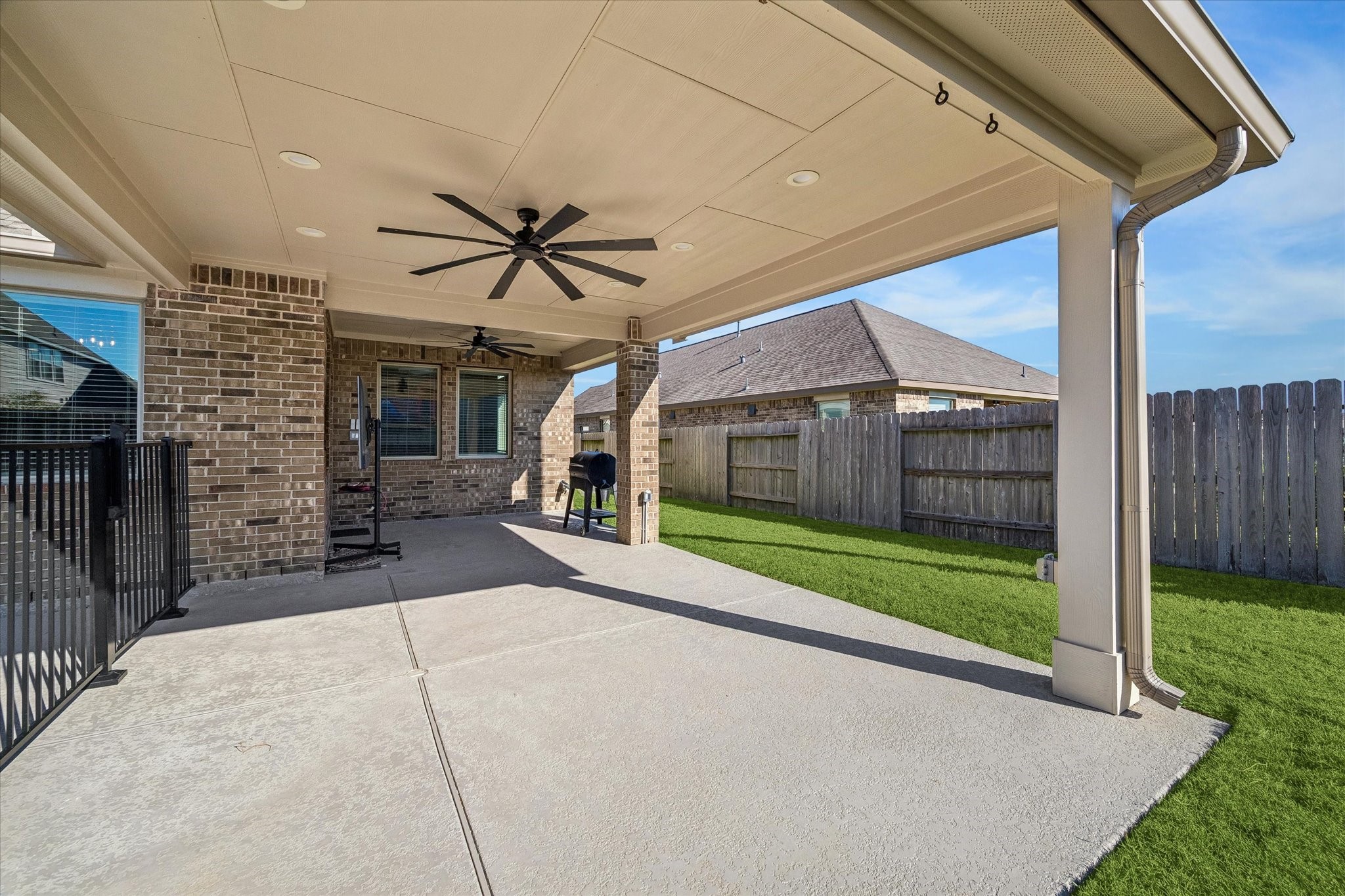 Extended in 2025, the covered patio offers generous space for outdoor dining and lounging, with upgraded ceiling fans and a gas connection ready for a future outdoor kitchen.