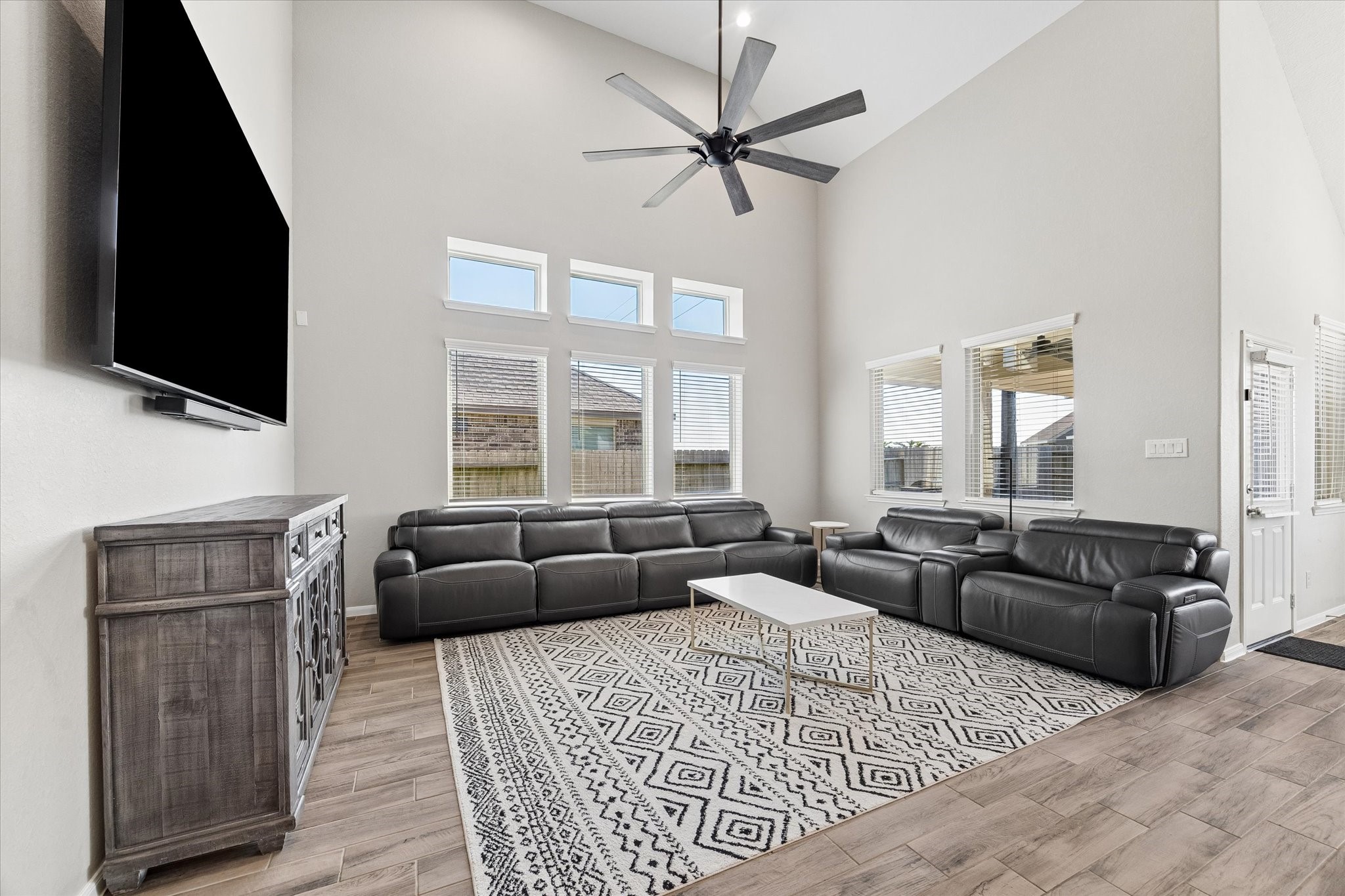 Stacked windows emphasize the living rooms impressive ceiling height, filling this comfortable gathering space with natural light.