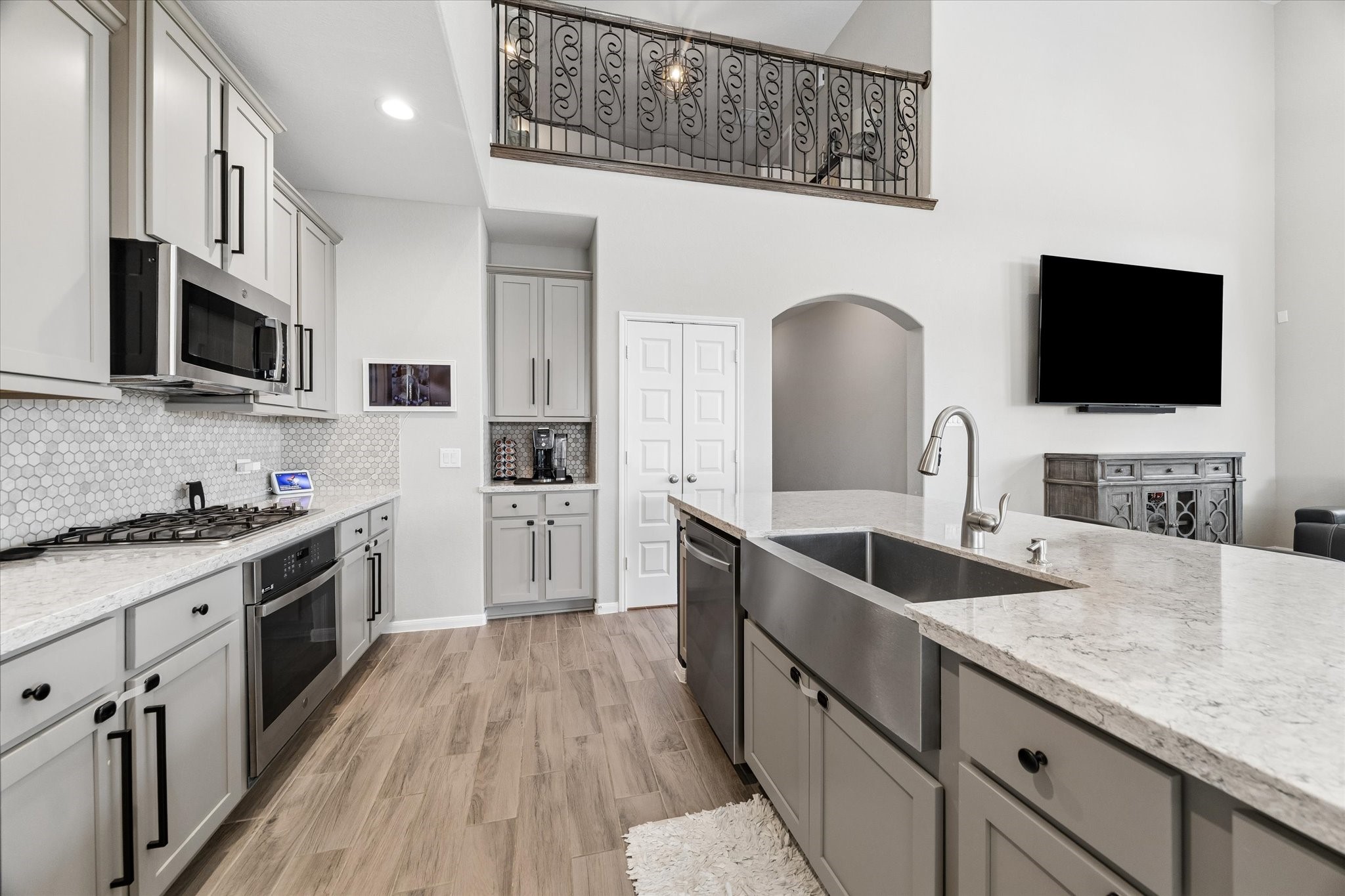 Light cabinetry, stainless steel appliances, and a generous island anchor a kitchen that stays connected to the main living area.