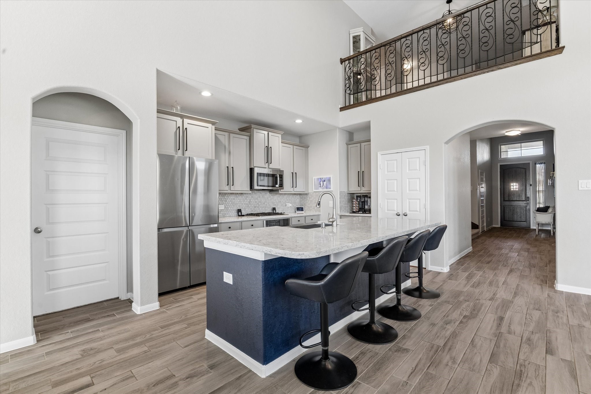 The kitchen opens to the main gathering space beneath an upper-level overlook, bringing architectural interest to the homes central hub.