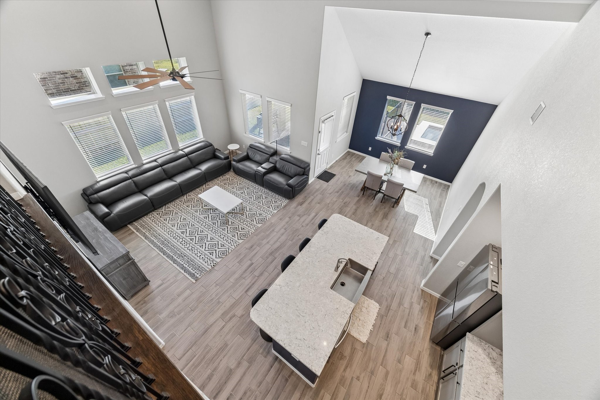 This view from above showcases the connected living, kitchen, and dining areas, highlighting the homes open layout and dramatic ceiling height.