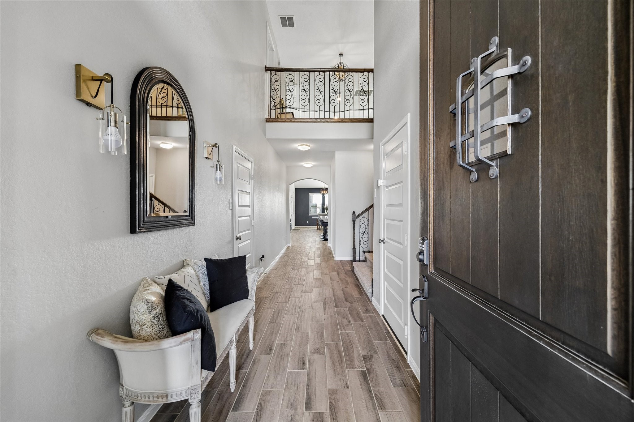 A soaring foyer, wood-look flooring, and an upper-level overlook create a memorable welcome from the moment you step inside.