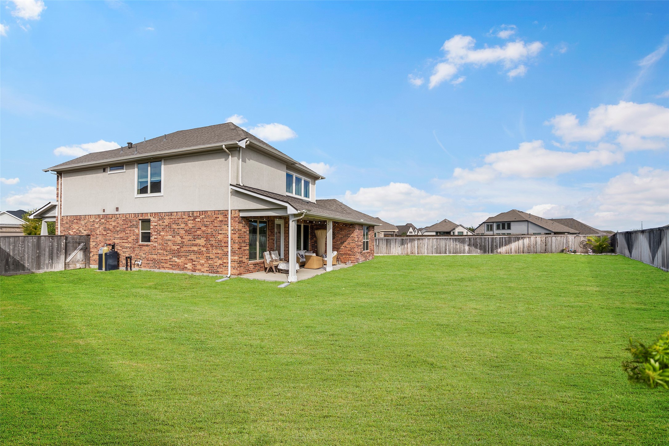 Rear exterior view showcasing the home and large backyard.