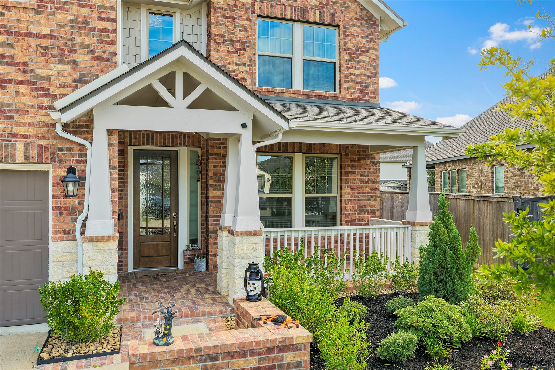 Welcoming front entry framed by attractive landscaping and a covered porch.