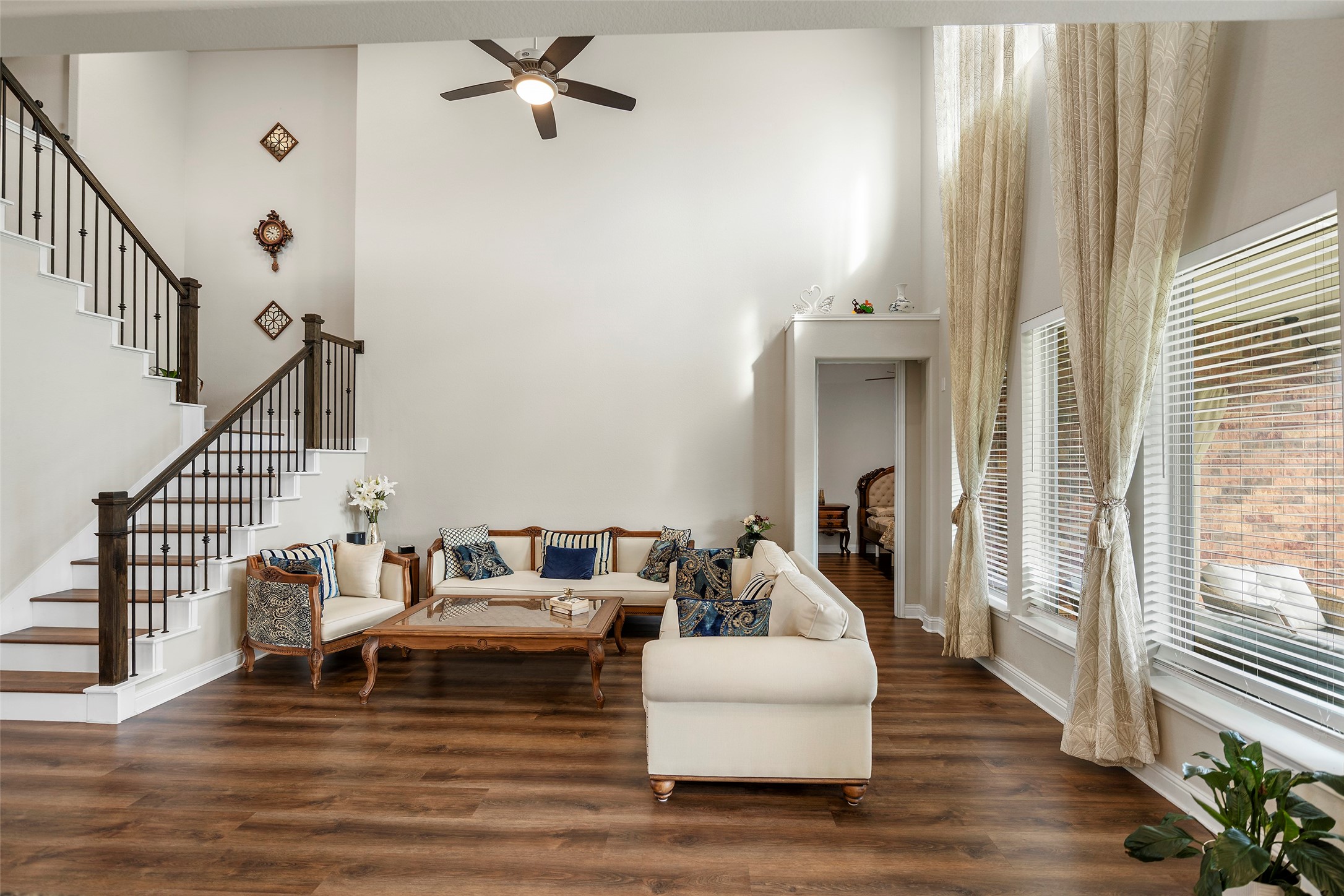 Spacious living room with soaring ceilings and tall windows bringing in abundant natural light.