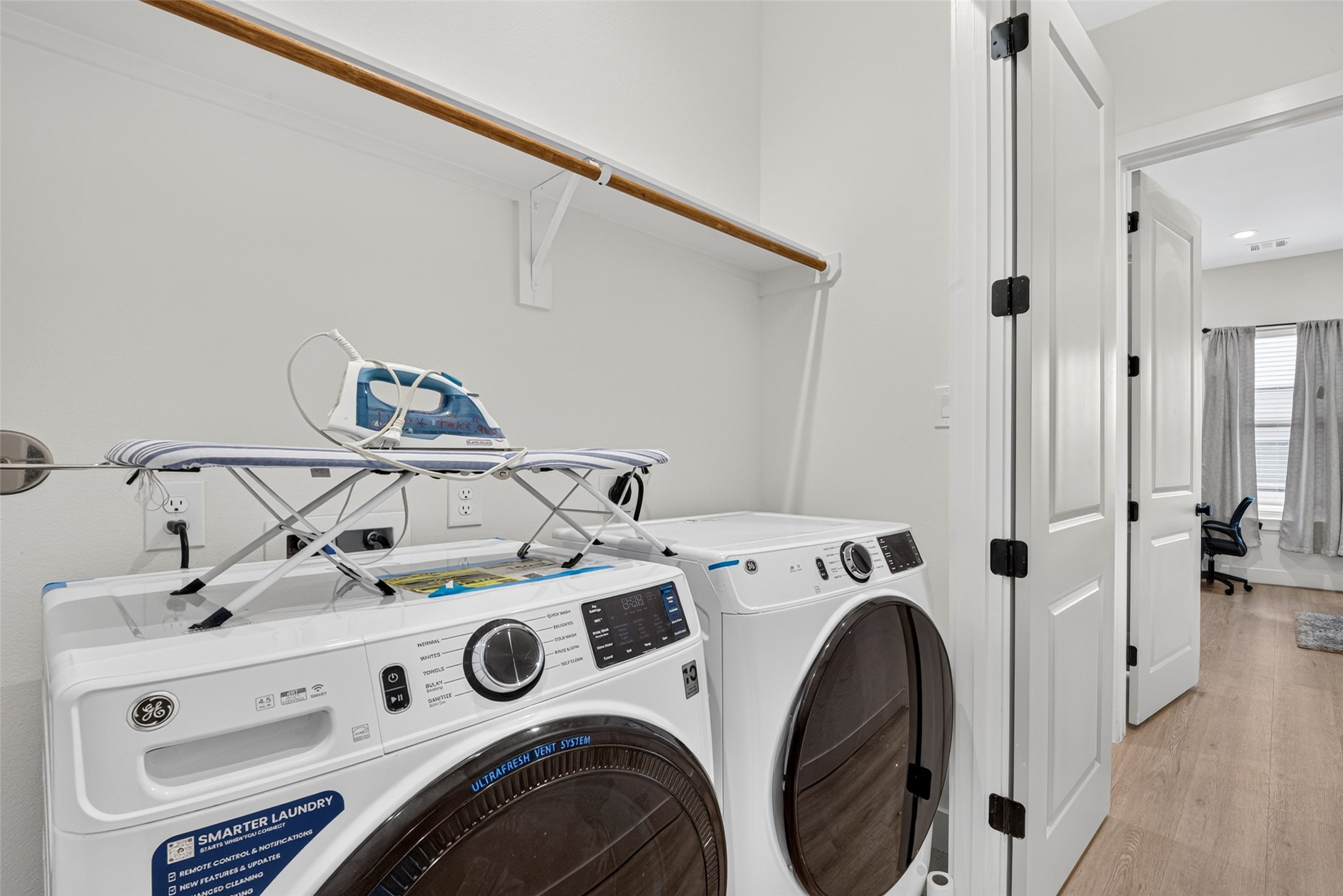 A dedicated laundry area optimizes space with built-in overhead storage shelving positioned above the appliance hookups.