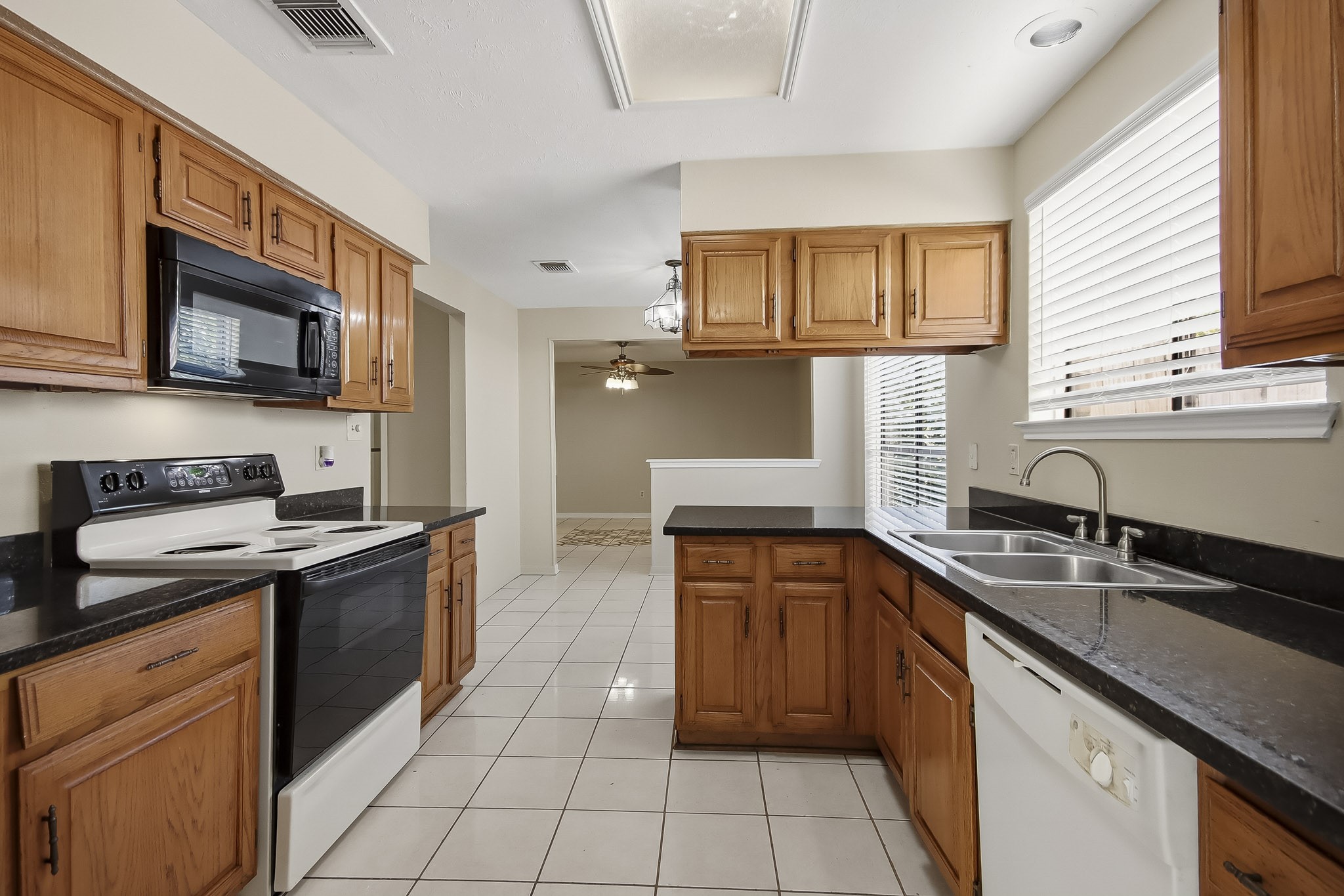 Another view of the kitchen, featuring ample cabinet space, a breakfast bar, and an opening to the adjoining living area.