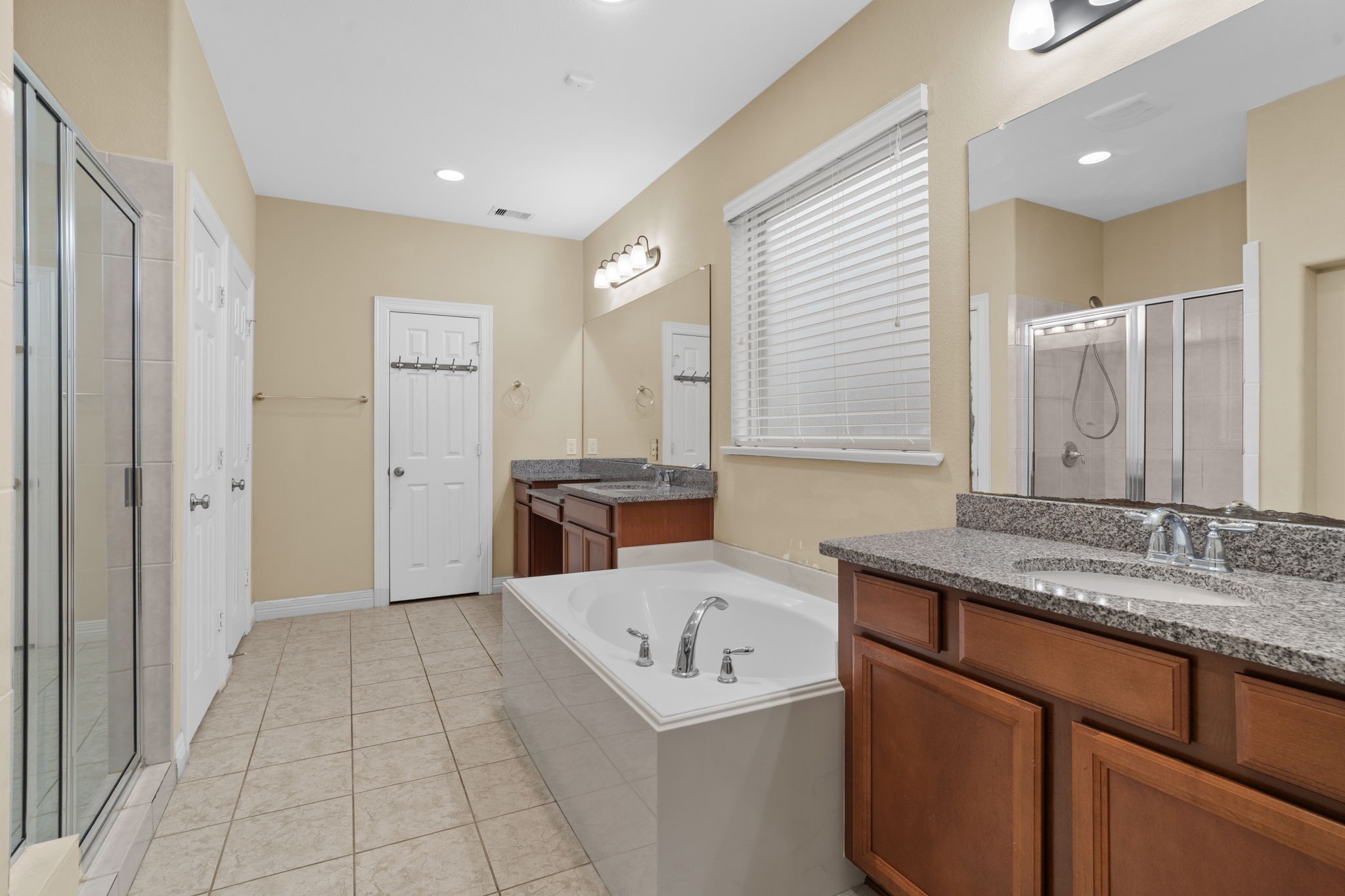 Relax in the soaking tub or enjoy a refreshing rinse in the separate walk-in shower. Designed for two, the spacious primary bath also features dual vanities, a linen closet, a private water closet, and an expansive walk-in closet.
