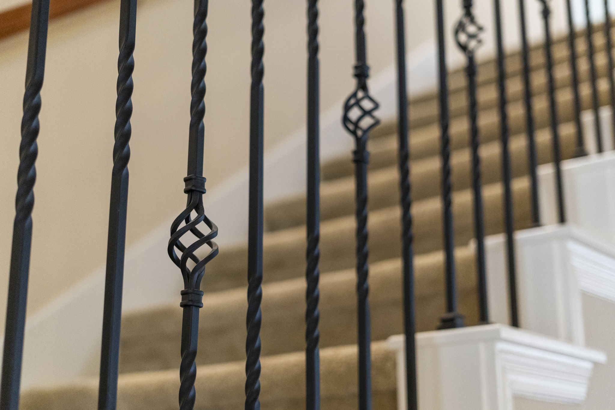 Classic staircase accented by wrought-iron balusters and rich wood details.