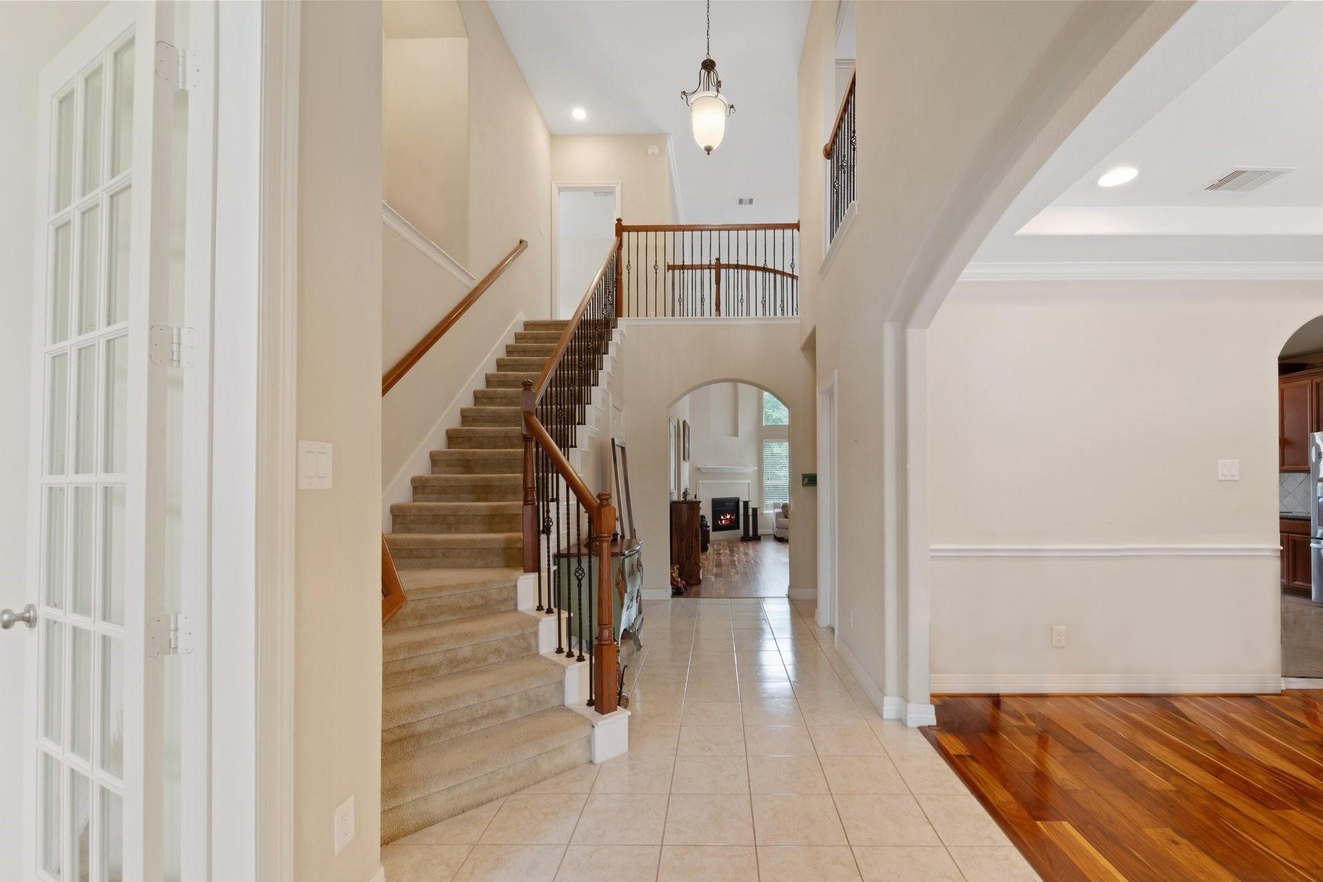 A grand two-story foyer with soaring ceilings and a sweeping staircase creates an impressive first impression.
