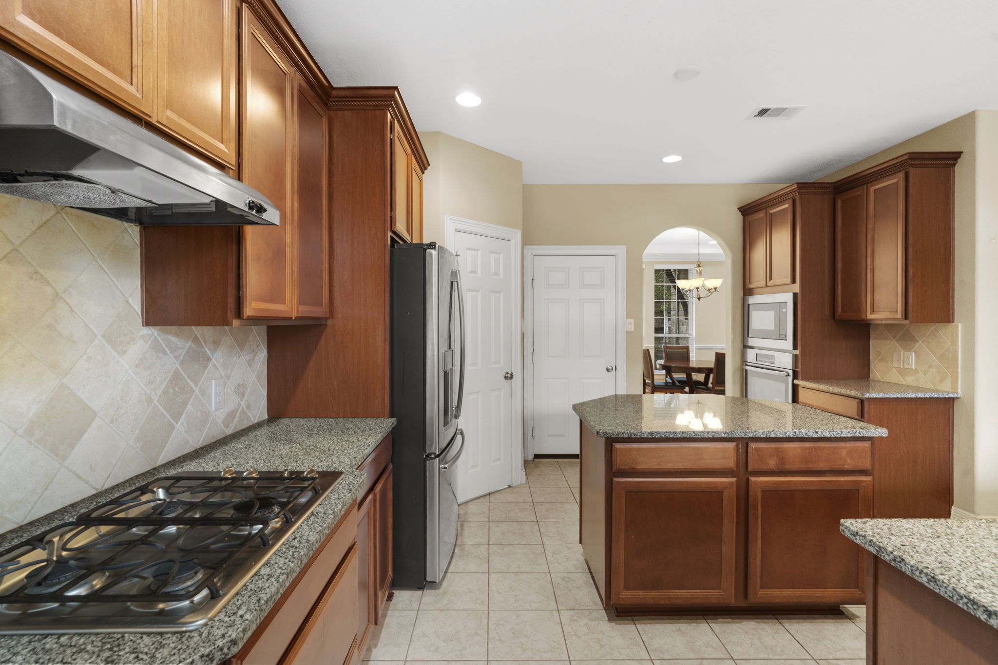 Gas cooktop, electric wall oven, and built-in microwave offer versatile cooking options.