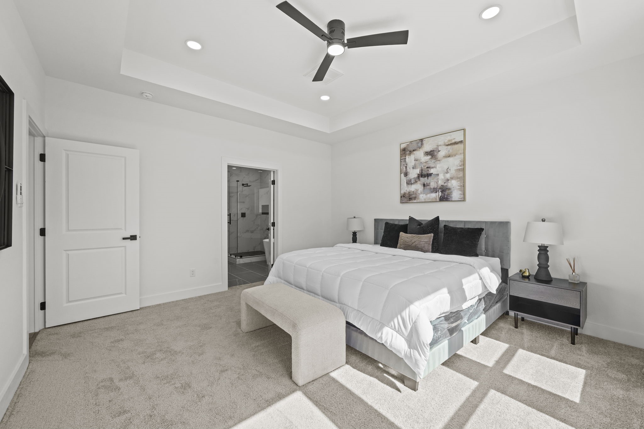 The primary bedroom is spacious with high ceilings.