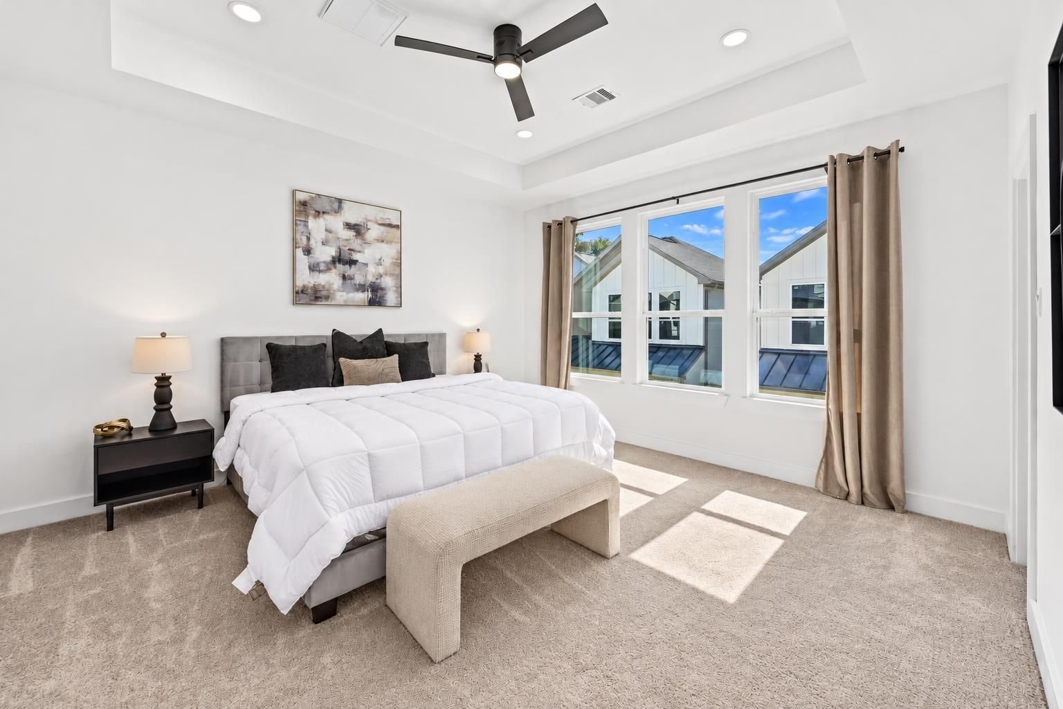 The primary bedroom has excellent natural lighting wih three large windows and an elevated ceiling.