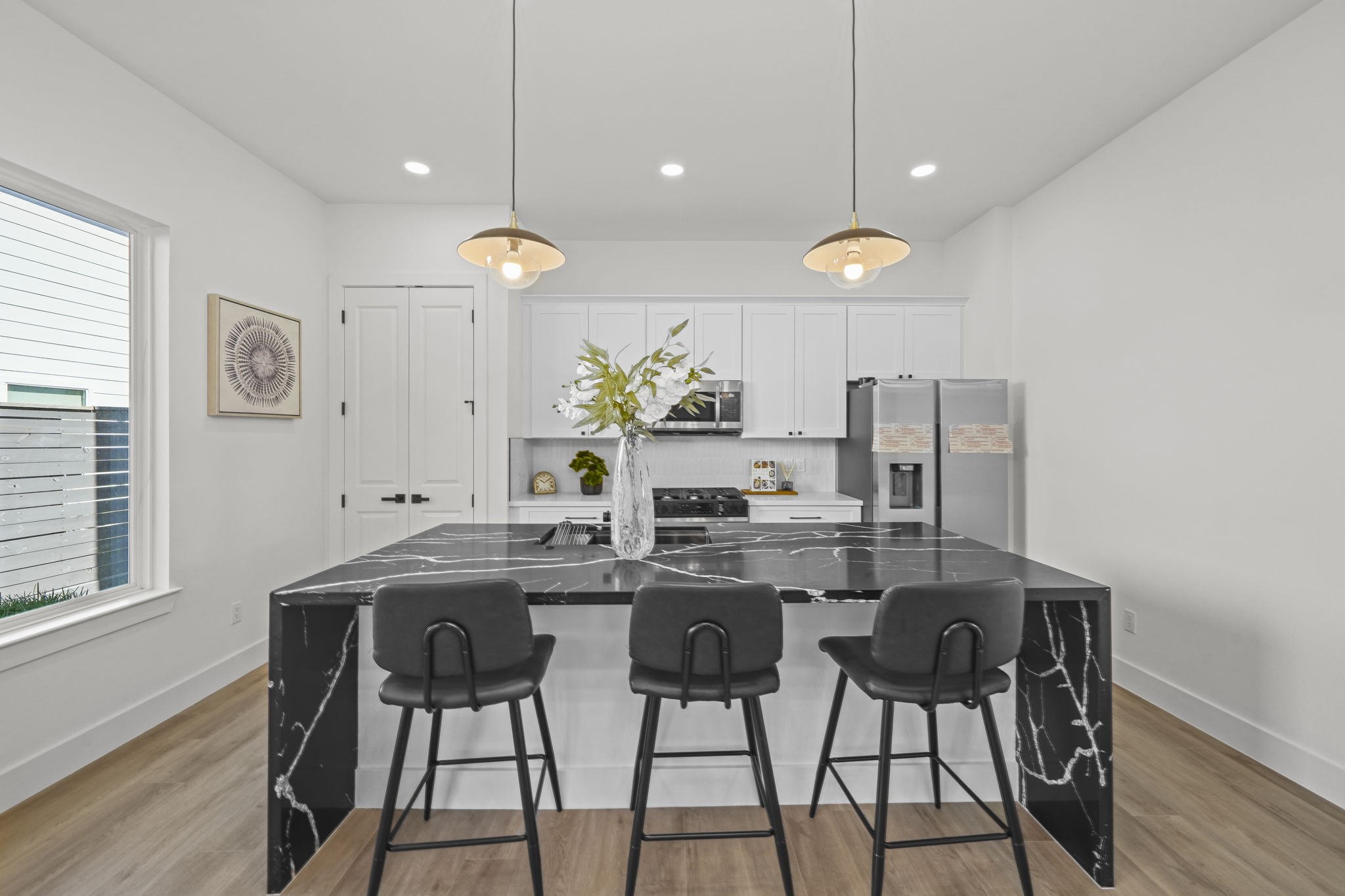 This modern home boasts an elevated kitchen, complete with a large island with a breakfast bar and stainless steel appliances. This modern home boasts an elevated kitchen, complete with a large island with a breakfast bar and stainless steel appliances.