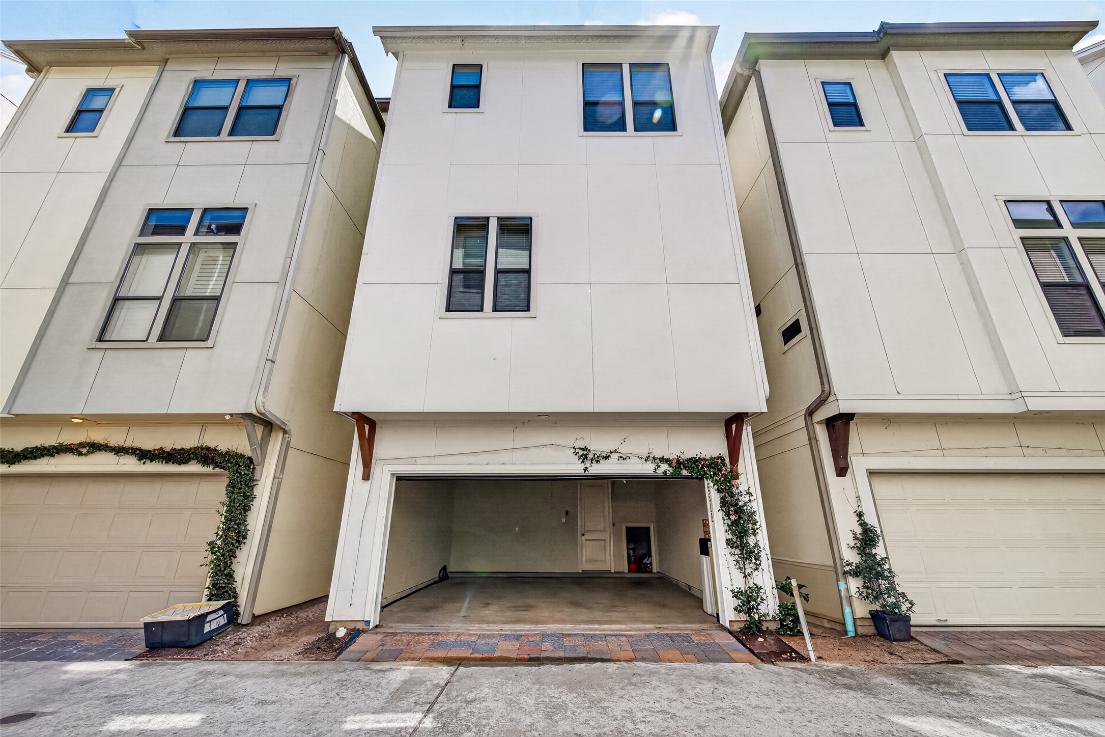 Contemporary townhouse with a spacious garage, clean lines, and ivy accents, offering modern urban living.