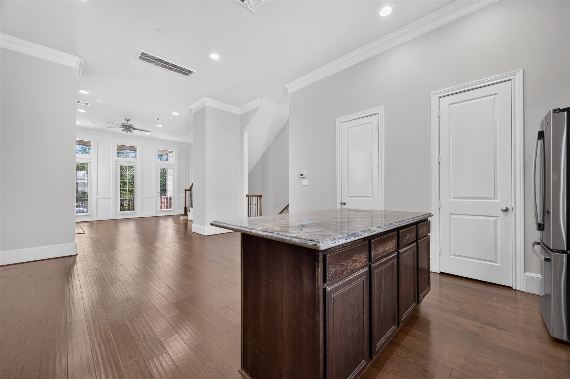 Bright and spacious open-concept living area with elegant hardwood floors, a modern kitchen island, and large windows for abundant natural light. Bright and spacious open-concept living area with elegant hardwood floors, a modern kitchen island, and large windows for abundant natural light.