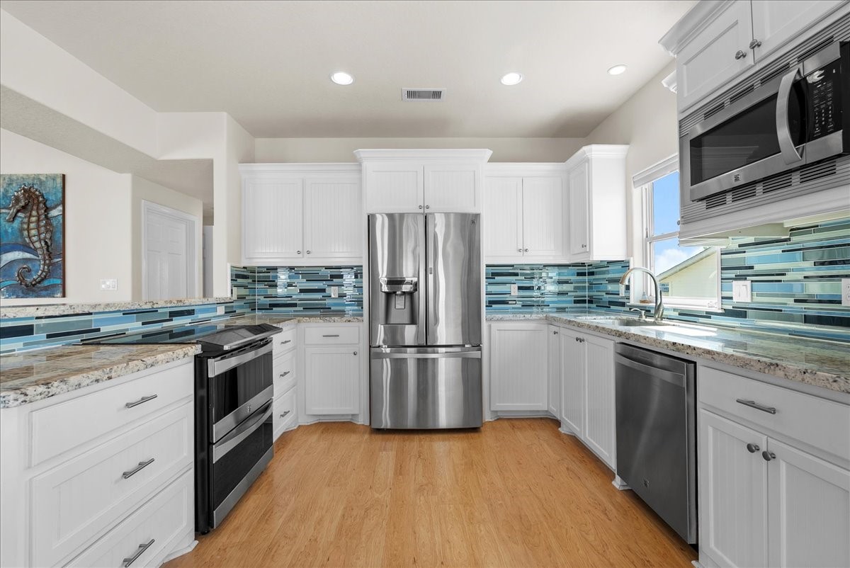 he kitchen impresses with designer backsplash, abundant cabinetry, stainless steel appliances, breakfast bar, and expansive granite countertops. he kitchen impresses with designer backsplash, abundant cabinetry, stainless steel appliances, breakfast bar, and expansive granite countertops.