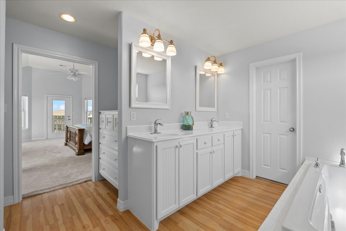 Spa-inspired en-suite with soaking tub, walk-in shower, dual sinks, and walk-in closet.
