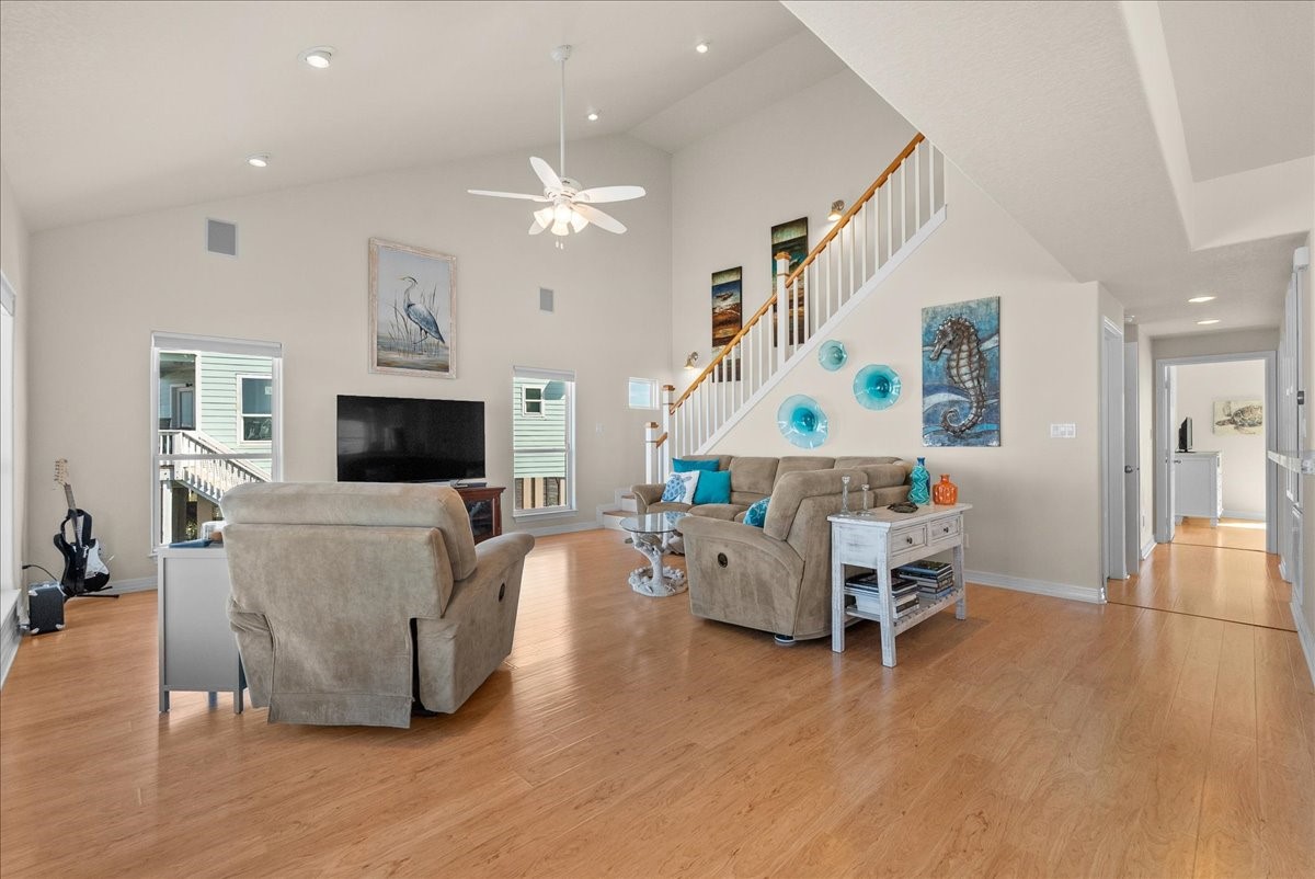 The spacious living room features soaring ceilings, an abundance of natural light, and expansive windows showcasing beautiful waterfront views. The spacious living room features soaring ceilings, an abundance of natural light, and expansive windows showcasing beautiful waterfront views.