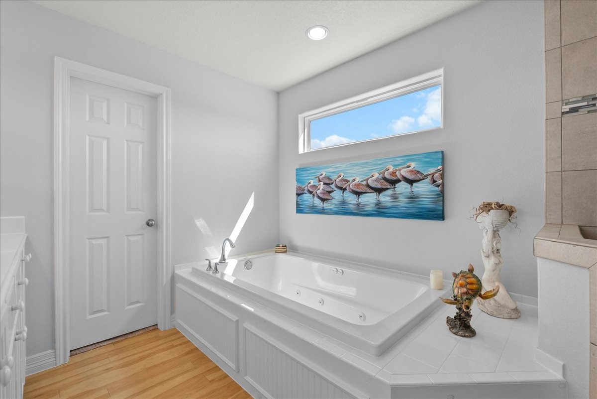 Spa-inspired en-suite with soaking tub, walk-in shower, dual sinks, and walk-in closet.