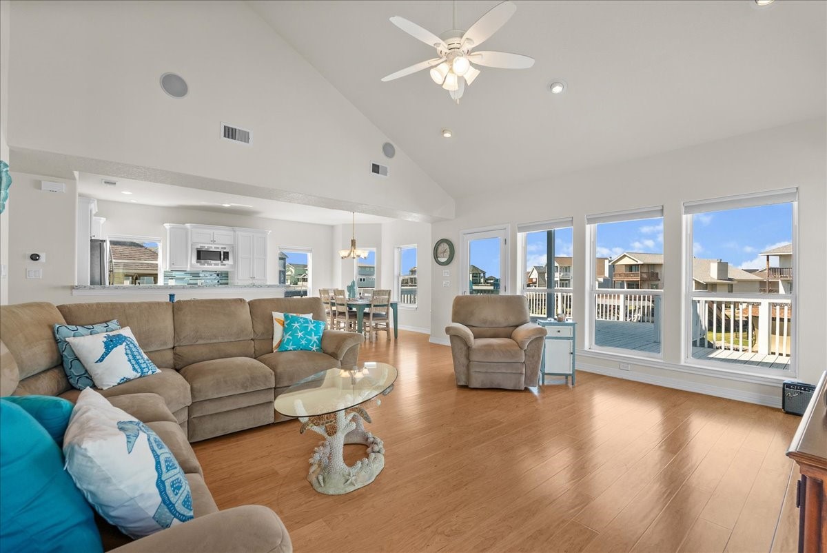 The spacious living room features soaring ceilings, an abundance of natural light, and expansive windows showcasing beautiful waterfront views. The spacious living room features soaring ceilings, an abundance of natural light, and expansive windows showcasing beautiful waterfront views.