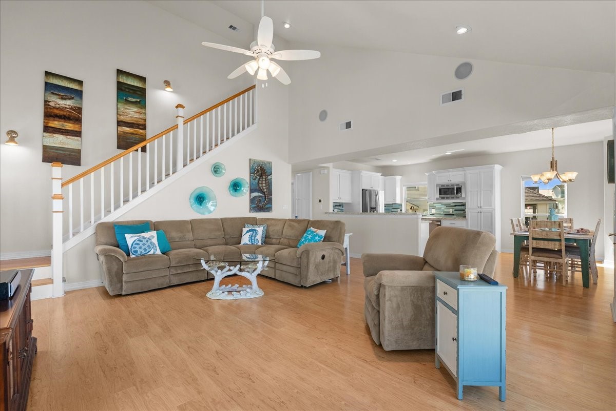 The spacious living room features soaring ceilings, an abundance of natural light, and expansive windows showcasing beautiful waterfront views. The spacious living room features soaring ceilings, an abundance of natural light, and expansive windows showcasing beautiful waterfront views.