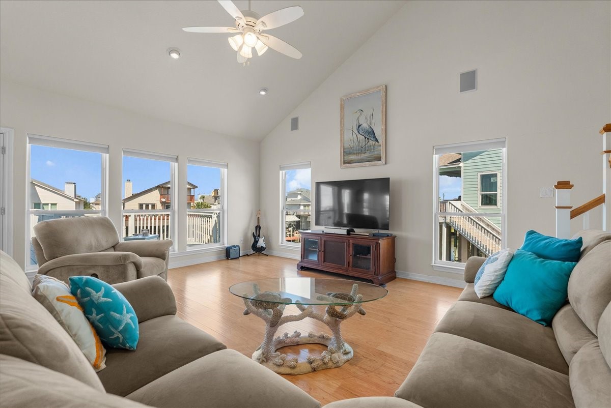The spacious living room features soaring ceilings, an abundance of natural light, and expansive windows showcasing beautiful waterfront views. The spacious living room features soaring ceilings, an abundance of natural light, and expansive windows showcasing beautiful waterfront views.