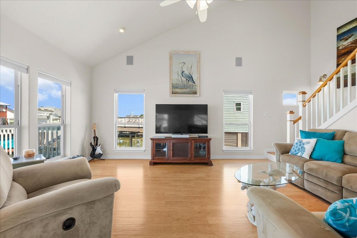 The spacious living room features soaring ceilings, an abundance of natural light, and expansive windows showcasing beautiful waterfront views. The spacious living room features soaring ceilings, an abundance of natural light, and expansive windows showcasing beautiful waterfront views.