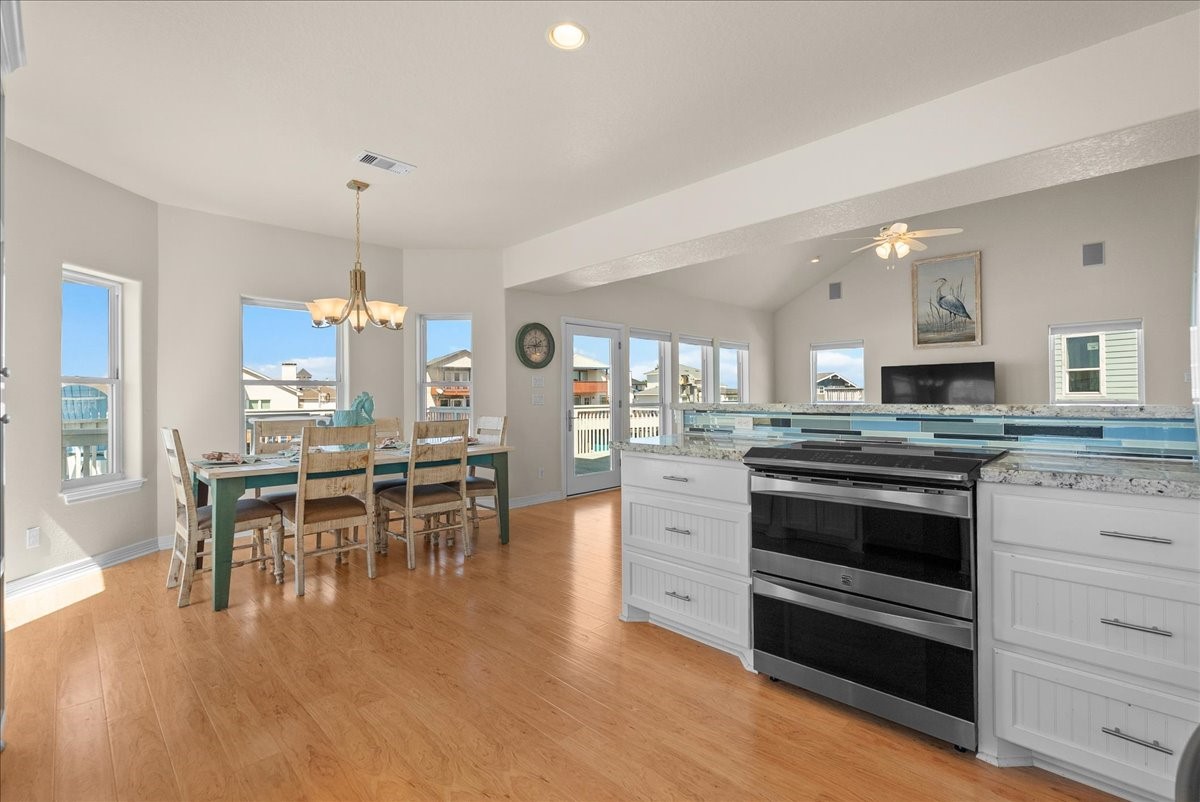 he kitchen impresses with designer backsplash, abundant cabinetry, stainless steel appliances, breakfast bar, and expansive granite countertops.