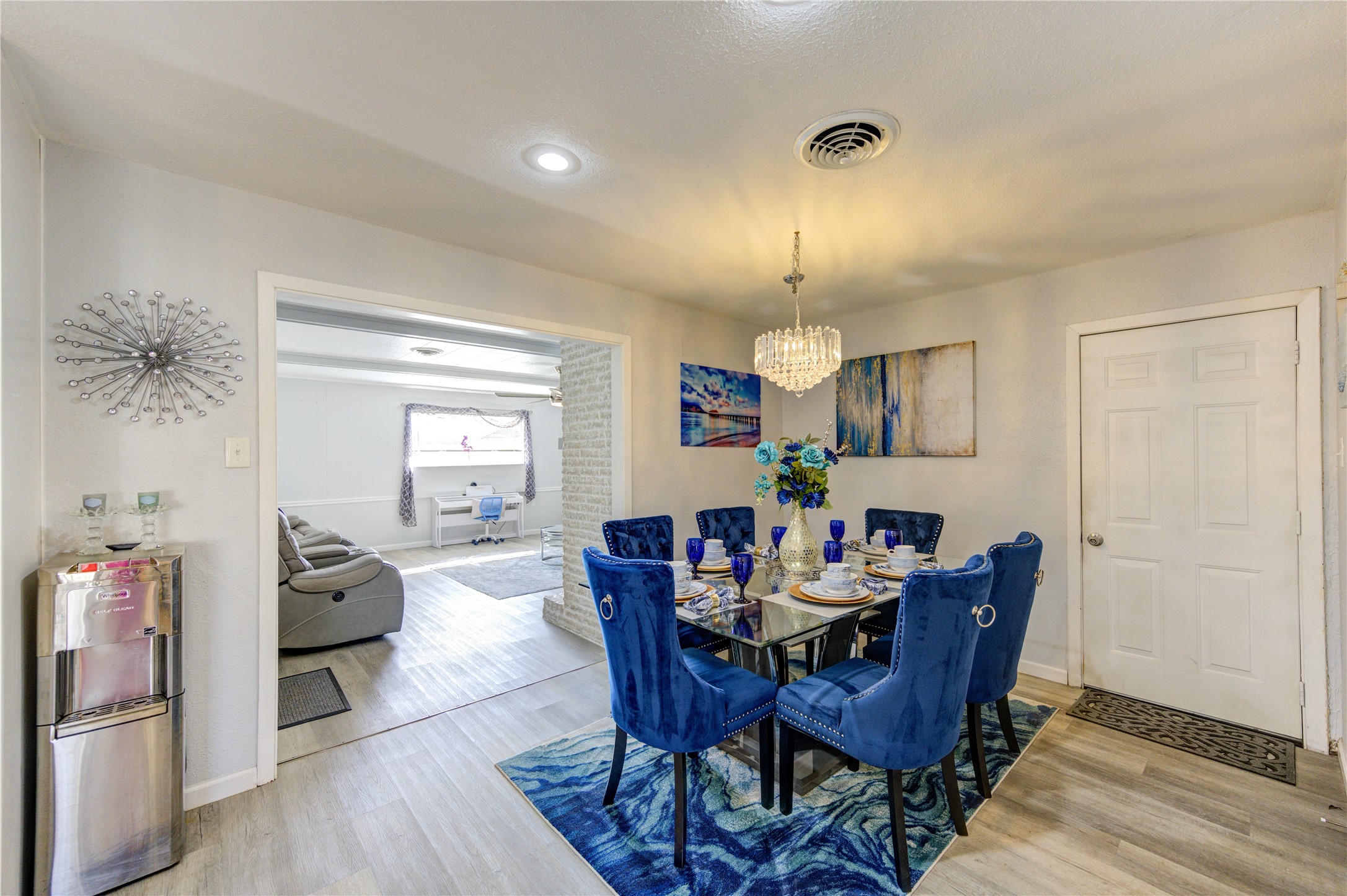 The inviting dining room is enhanced by a modern chandelier.