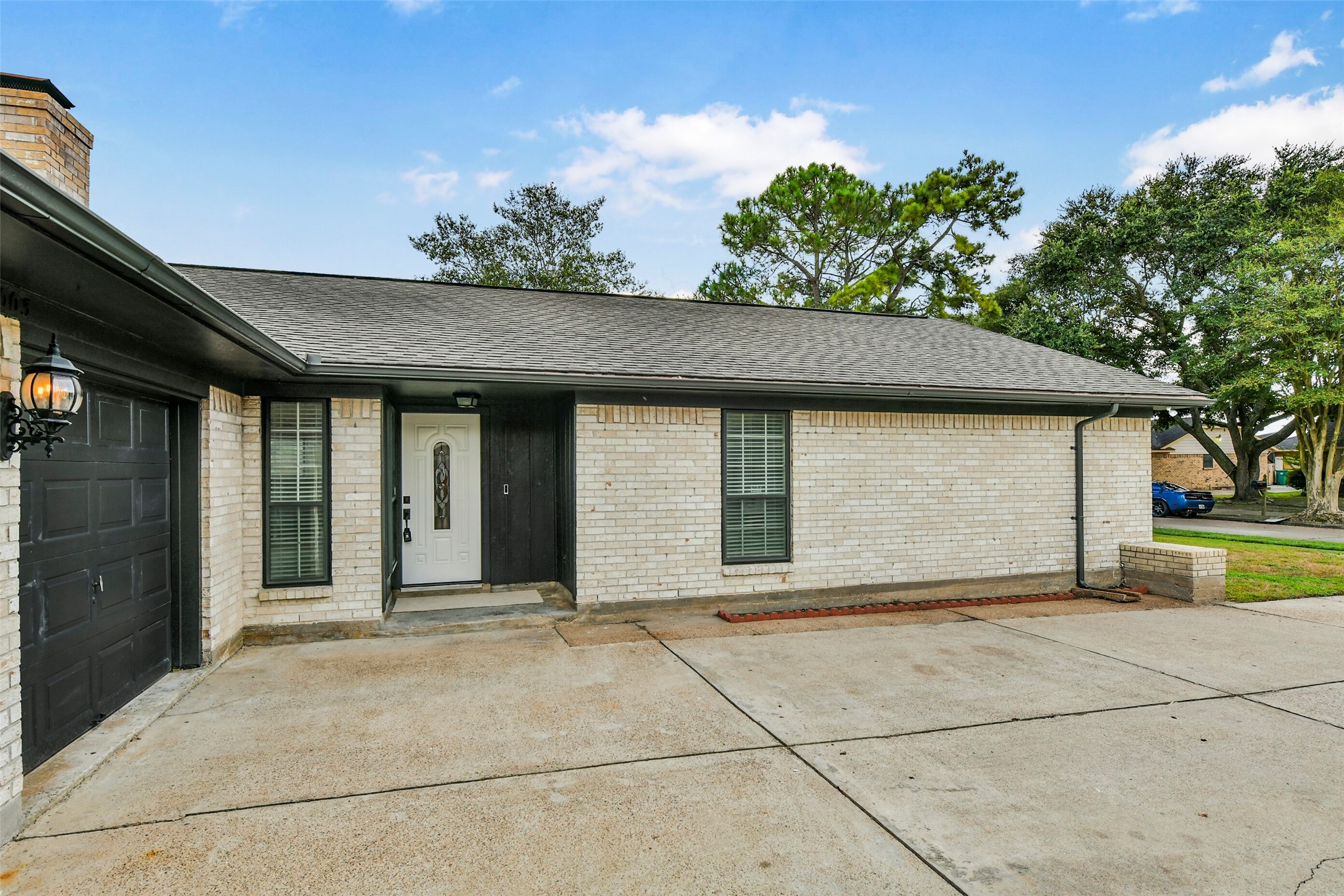 Brick home with a spacious driveway leading to a two-car garage, featuring a welcoming front entrance and a well-maintained exterior. Brick home with a spacious driveway leading to a two-car garage, featuring a welcoming front entrance and a well-maintained exterior.