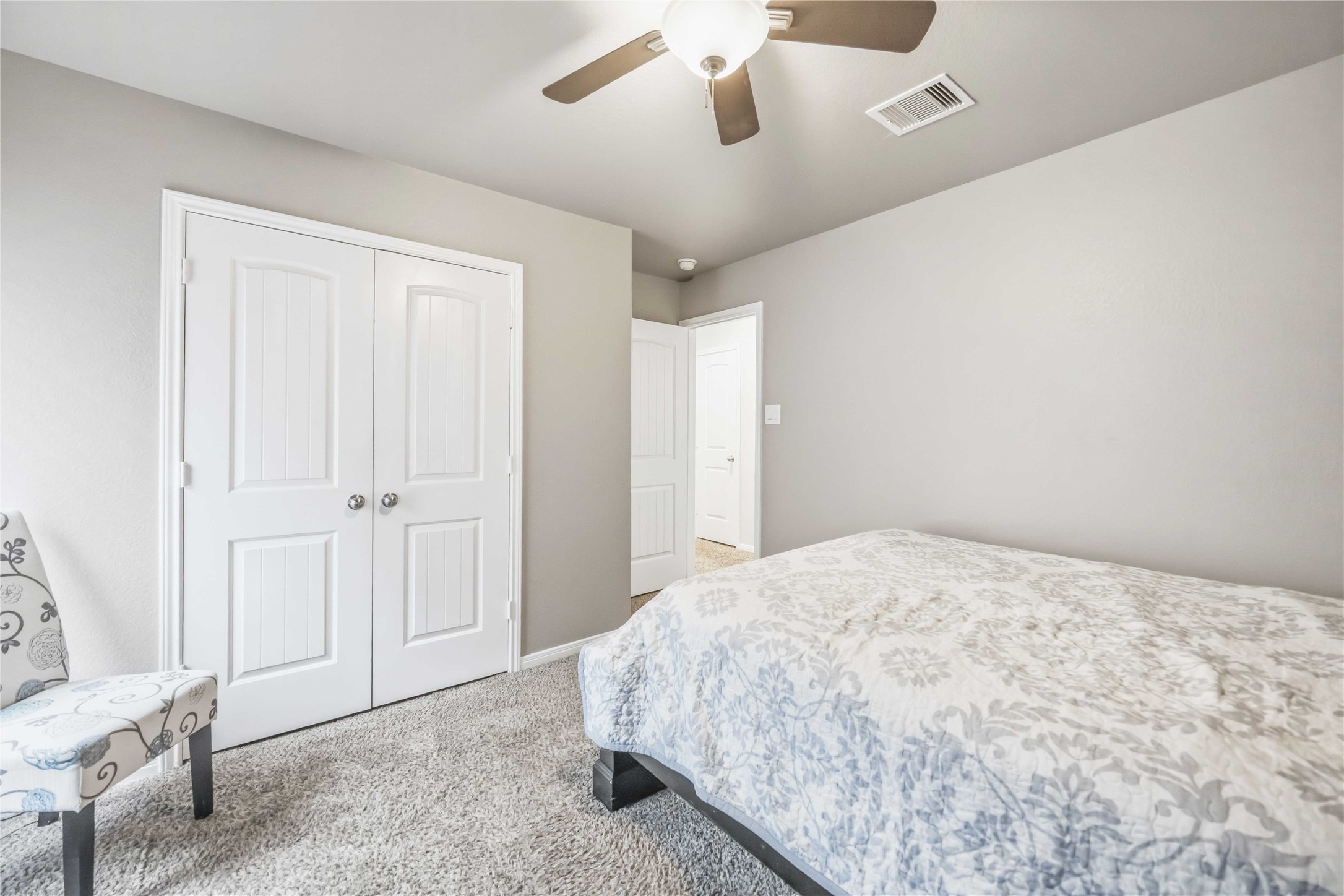 Cozy bedroom 1 featuring a plush carpet, soft neutral tones, and ample closet space.