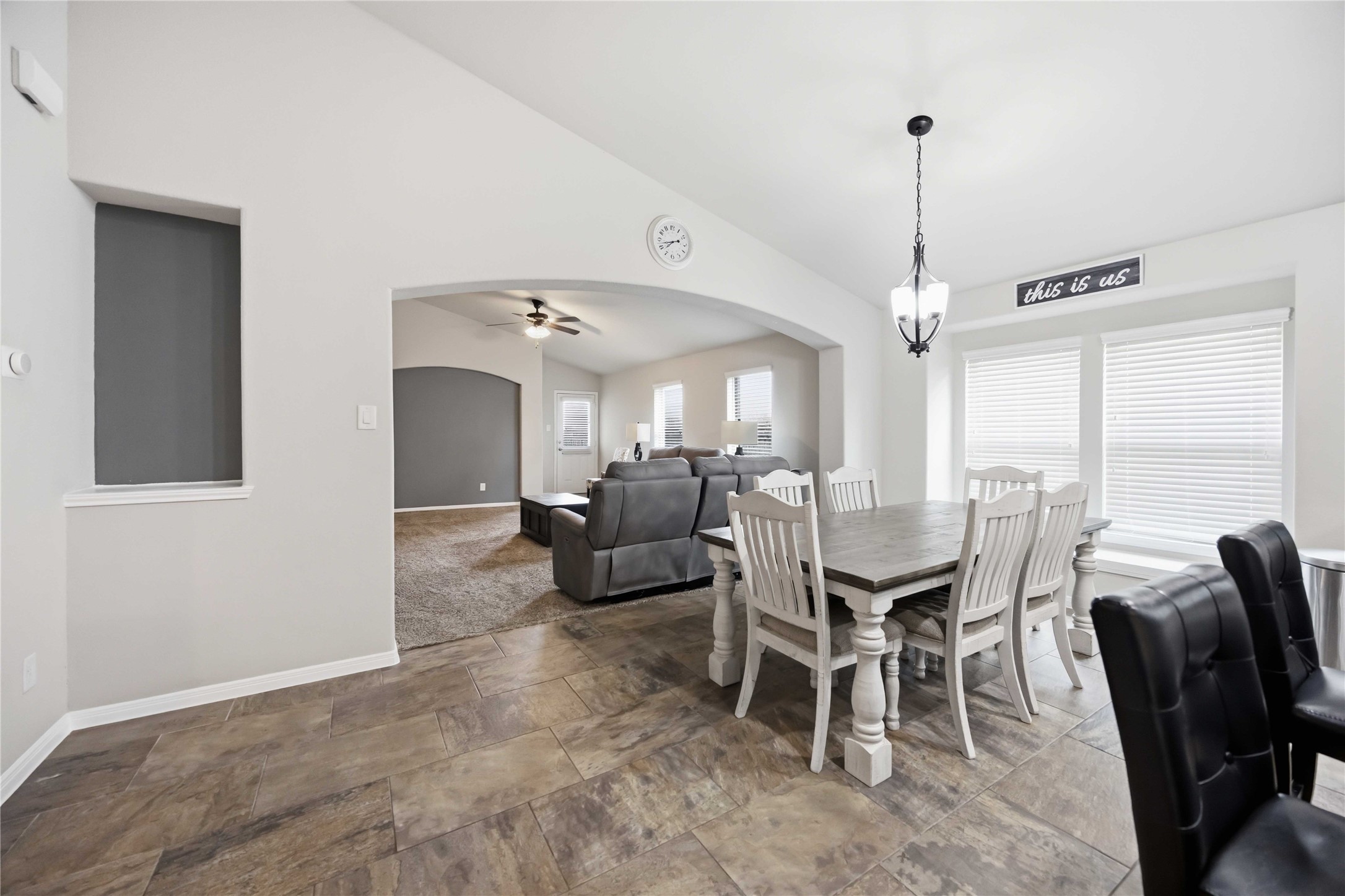 Bright and inviting open-concept living area featuring a cozy dining space with natural light, seamlessly flowing into a comfortable lounge area with plush seating and neutral tones.