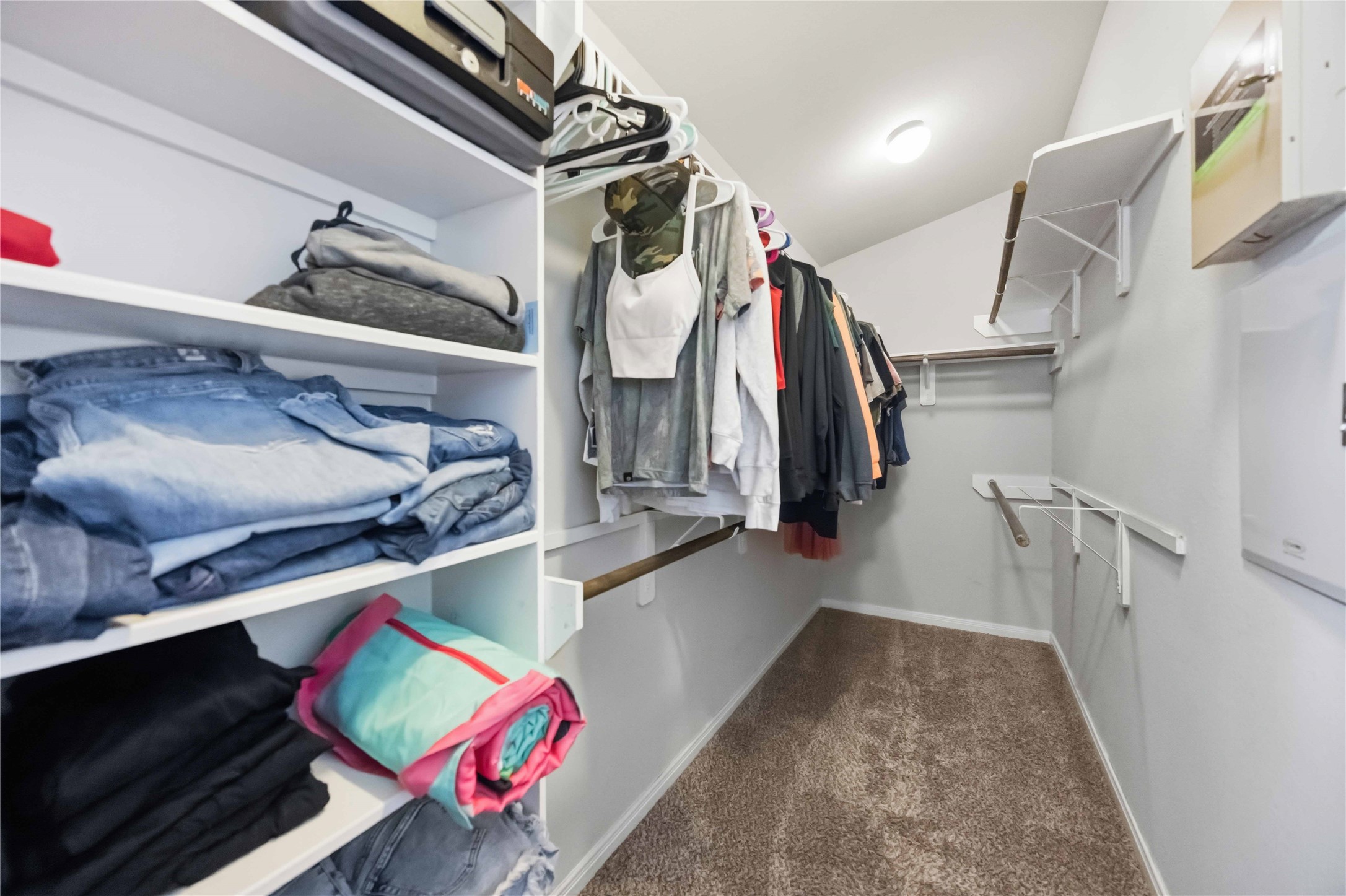 Spacious walk-in closet with ample shelving and hanging space, perfect for organizing your wardrobe efficiently.