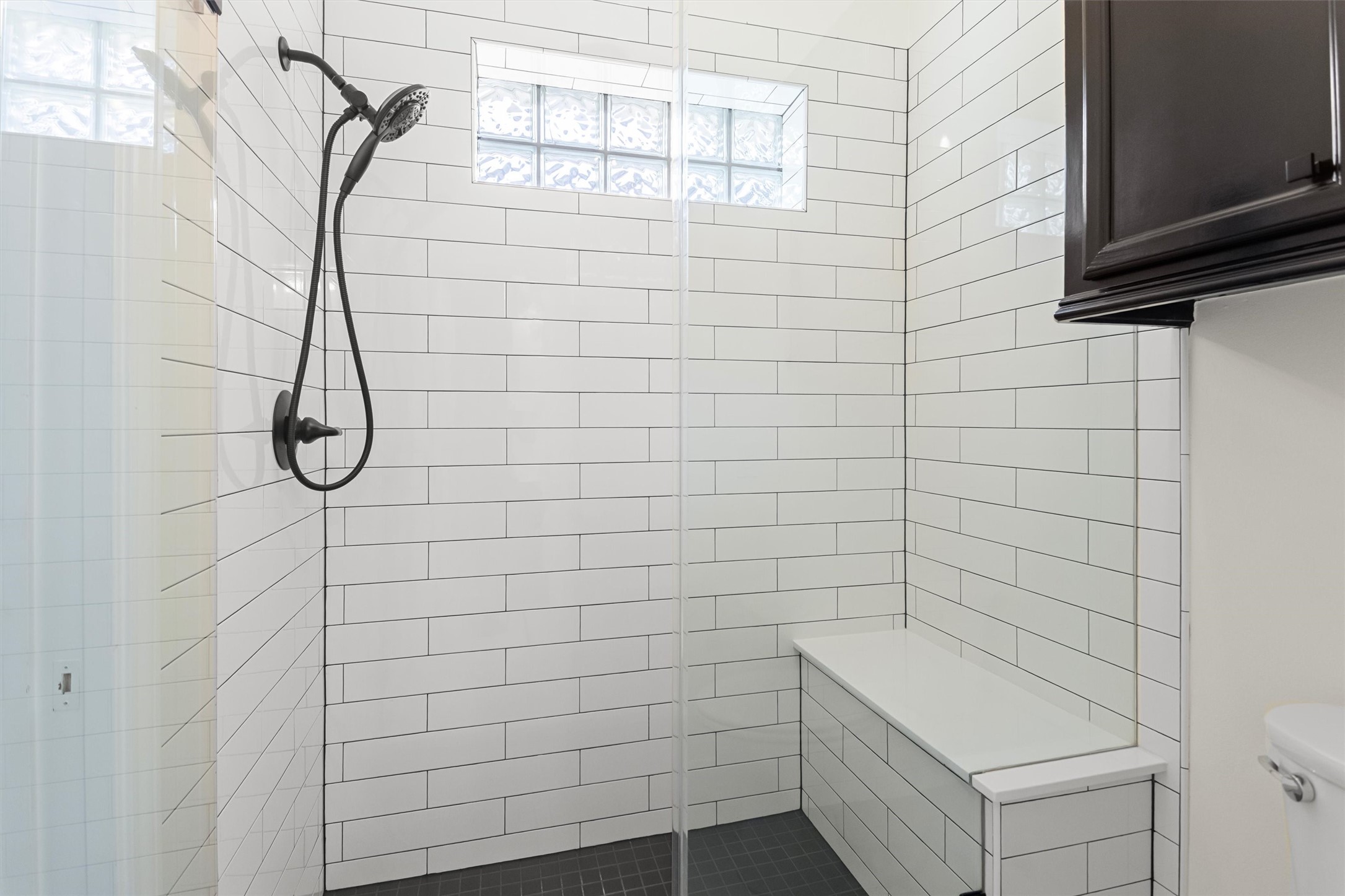 The secondary Hollywood bath features a spacious walk-in shower with a built-in bench.