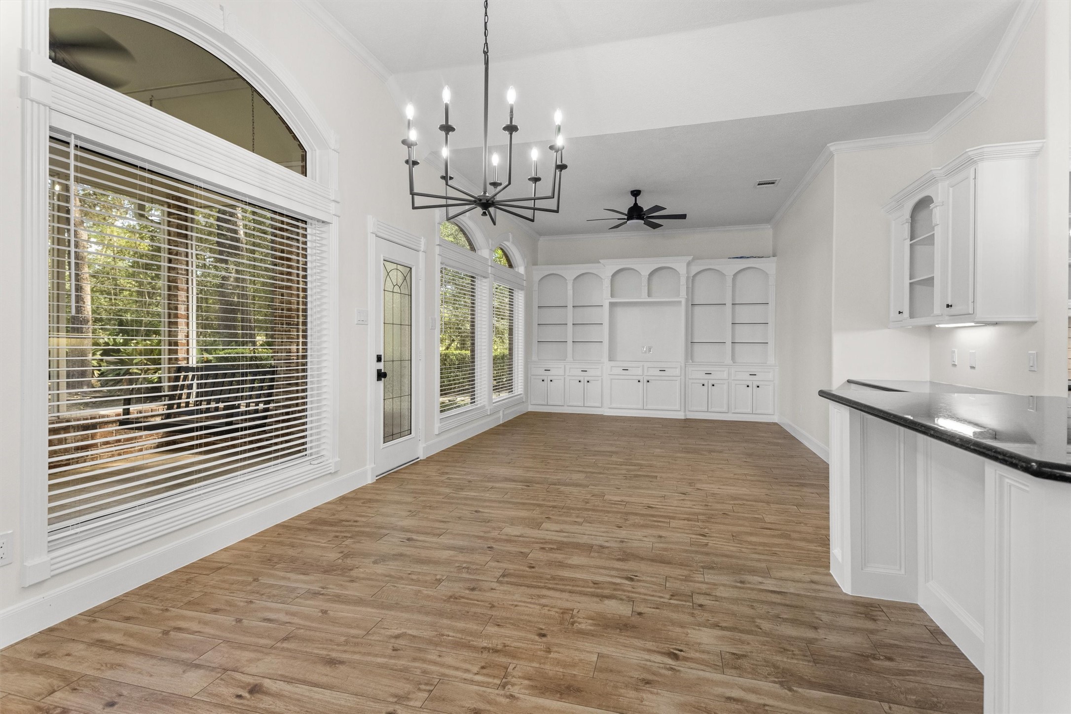 The heart of the home! The breakfast area, breakfast bar, and den come together to create an inviting space for everyday living and gathering. Thoughtful craftsmanship shines through in the beautifully cased windows, custom built-ins, and elegant crown molding.