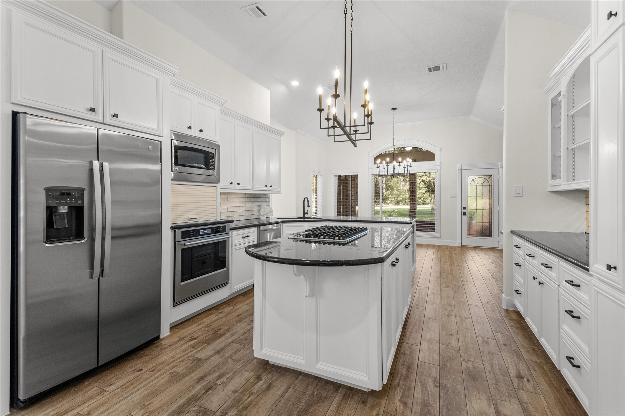 Bring your pots and pans to this newly updated kitchen, featuring a new oven, stove, flooring, paint, fixtures, and hardware. While modernized, the kitchen retains the charm of its 1996 design, complete with an appliance garage and abundant cabinetry for storage.