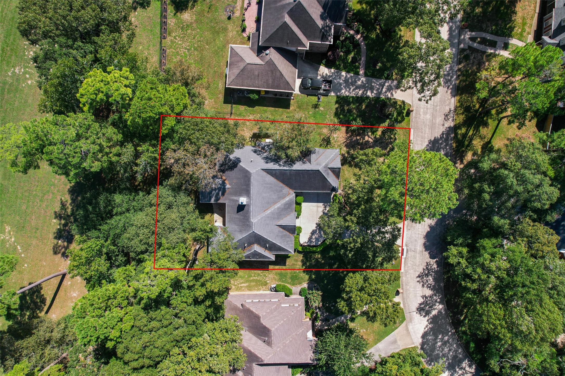 Aerial view showcasing the spacious lot and the beautiful mature oak trees providing ample shade.