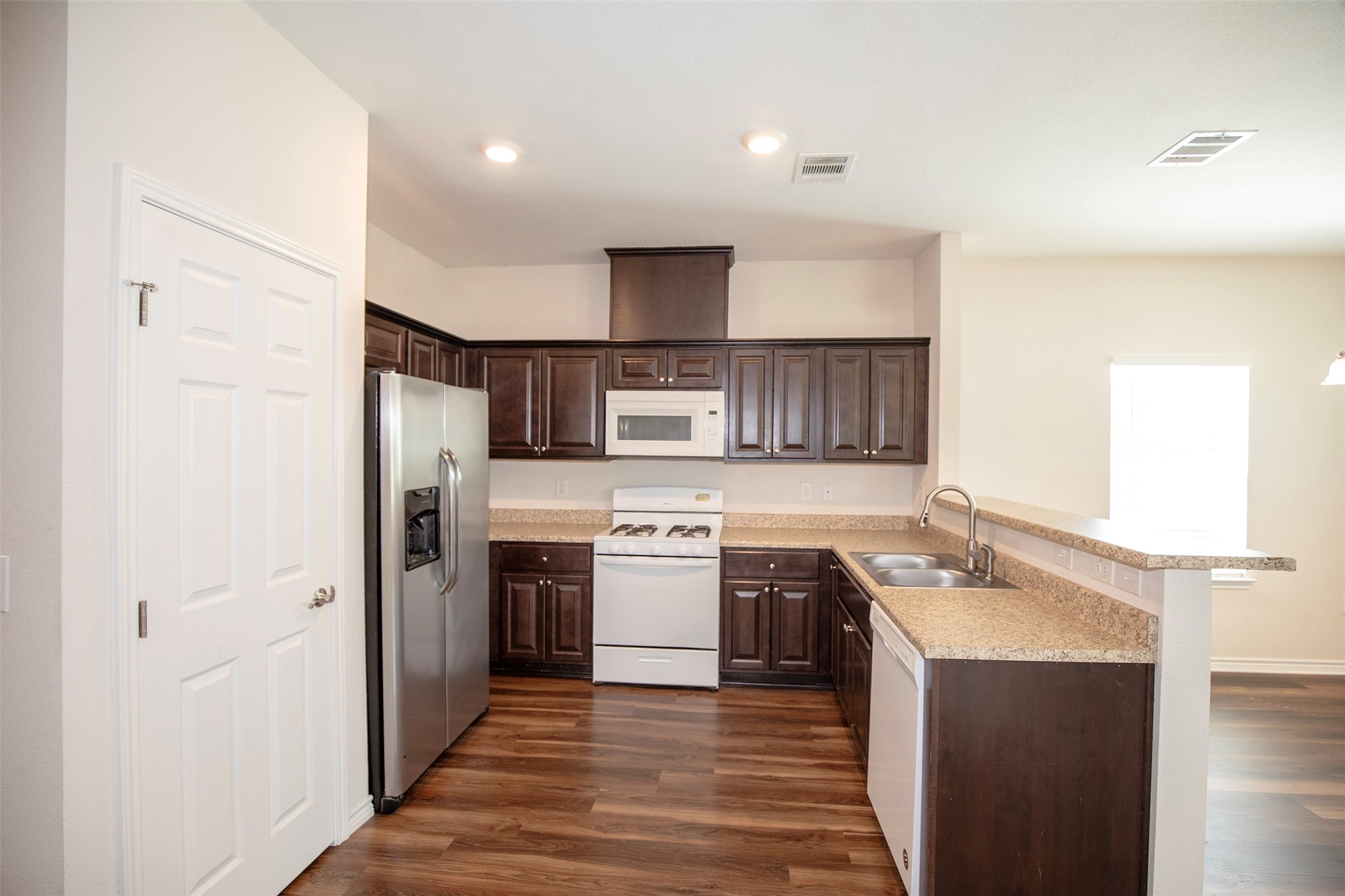 The kitchen features beautiful, dark cabinetry.