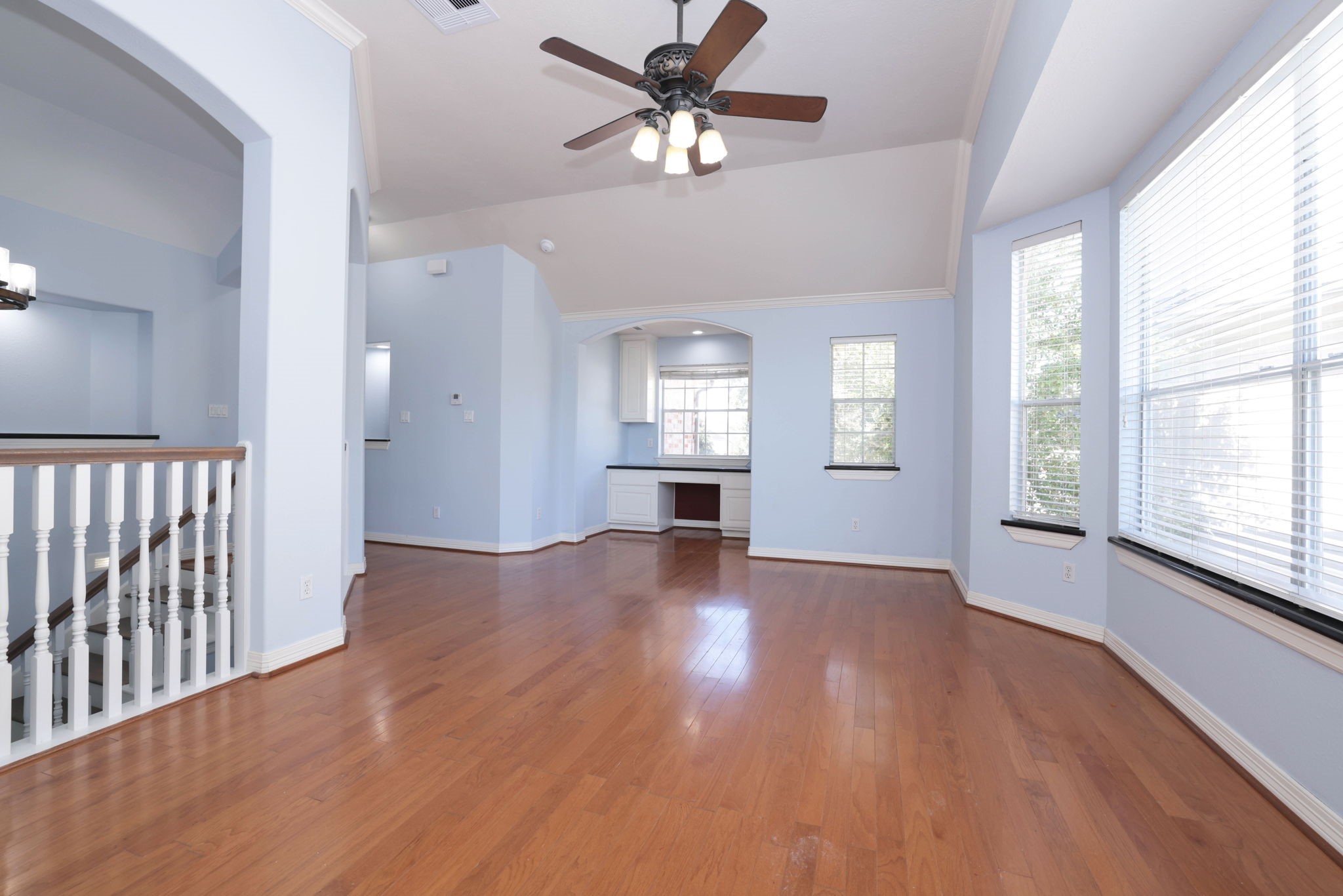 The spacious game room continues with wood floors and granite window sills.
