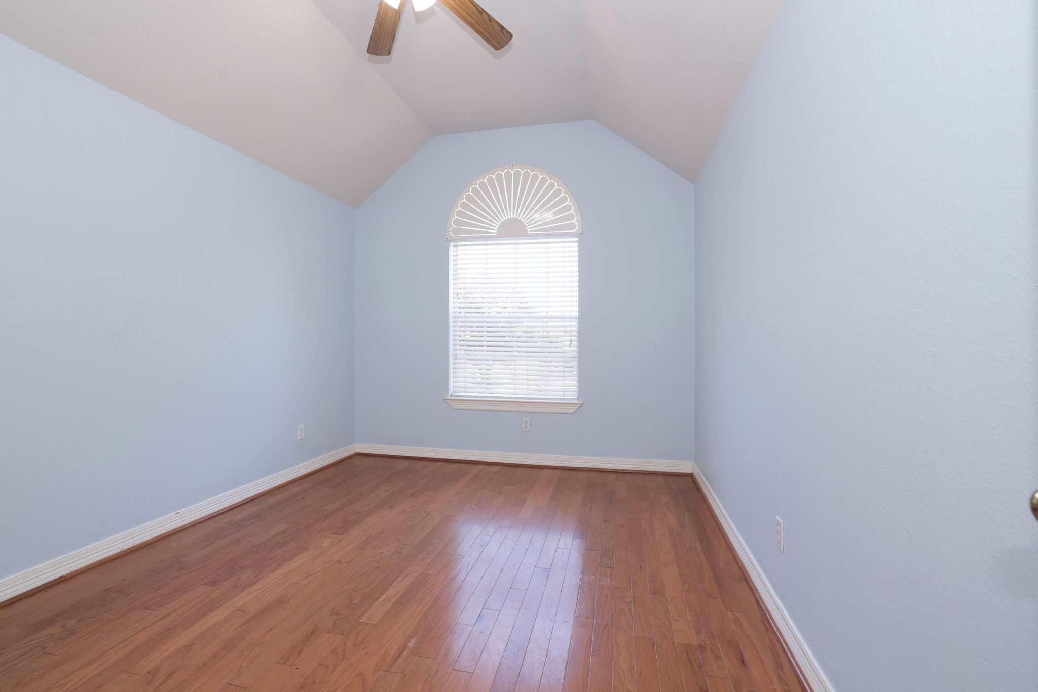 Bedroom 3 continues with wood floor, tall ceiling, fan anf fresh paint.