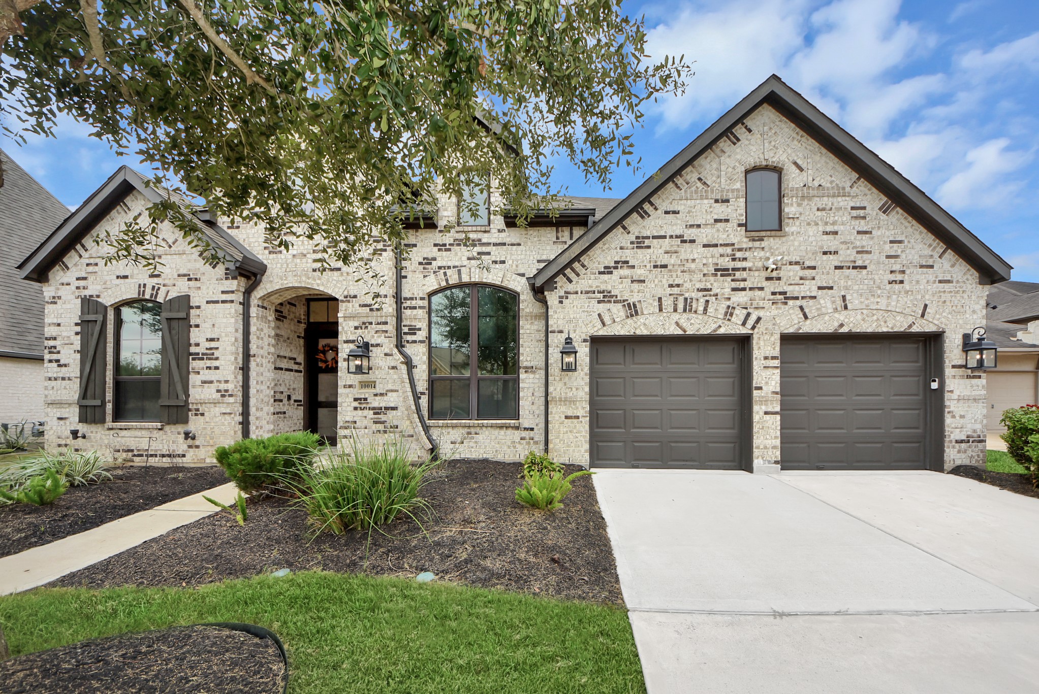 Welcoming front elevation featuring attractive landscaping and a spacious driveway.