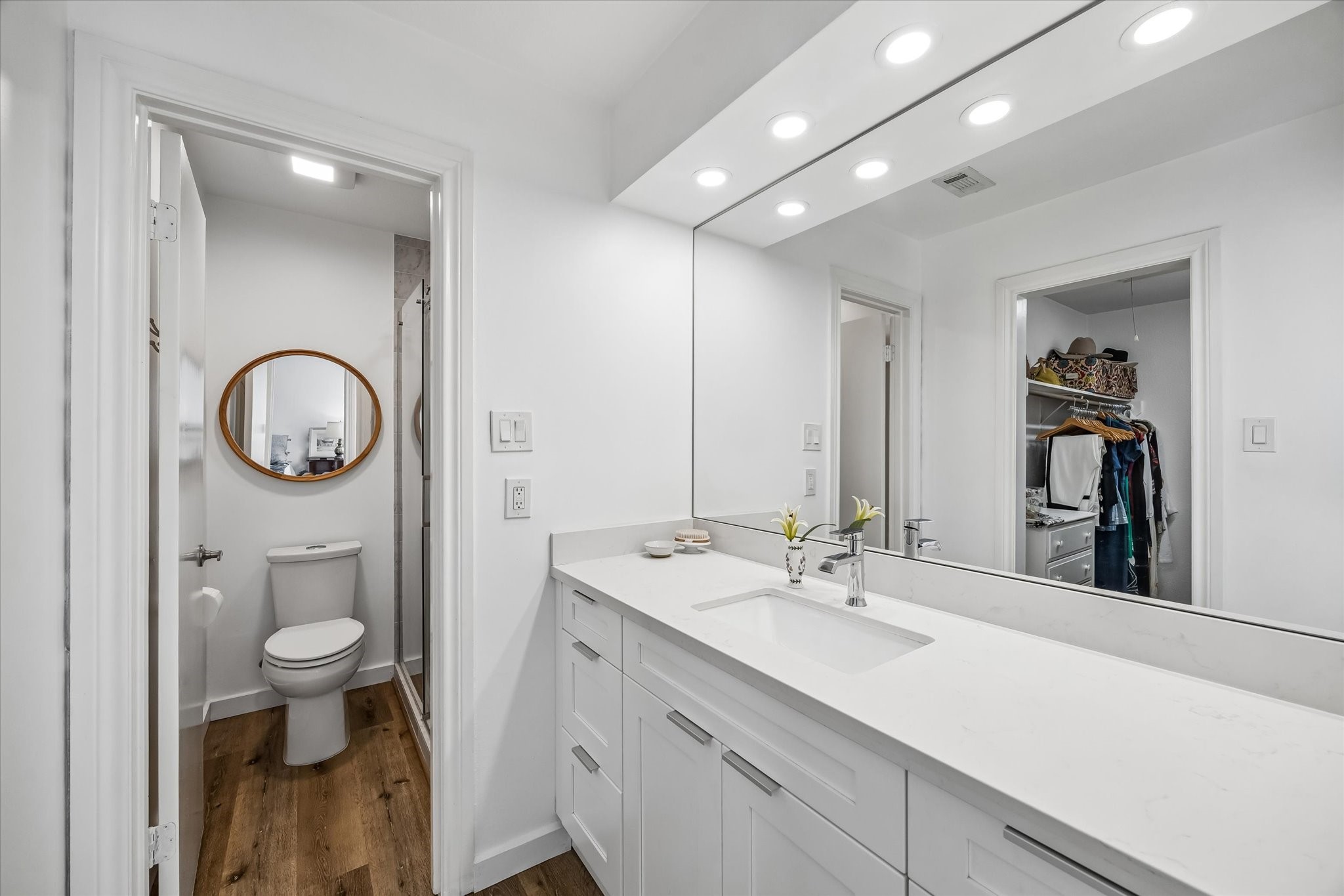 Fully renovated bathroom with new vanity, quartz countertop, tile, toilet, plumbing fixtures, lighting, mirrors and hardware.  New vinyl plank floors.