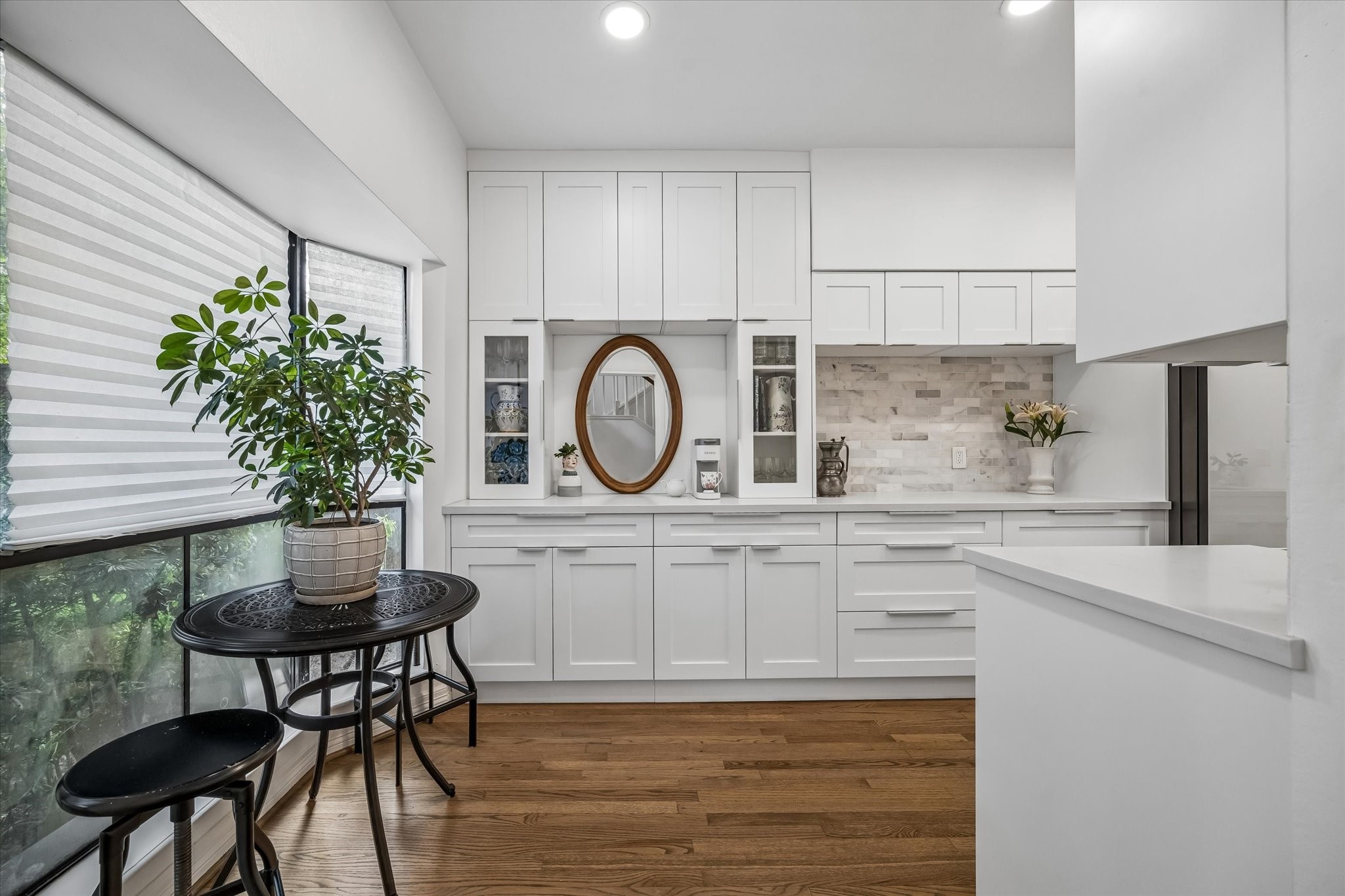 Fully renovated kitchen complemented by a cozy breakfast nook with natural light. Premium soft-close cabinetry, quartz countertops and natural marble backsplash.