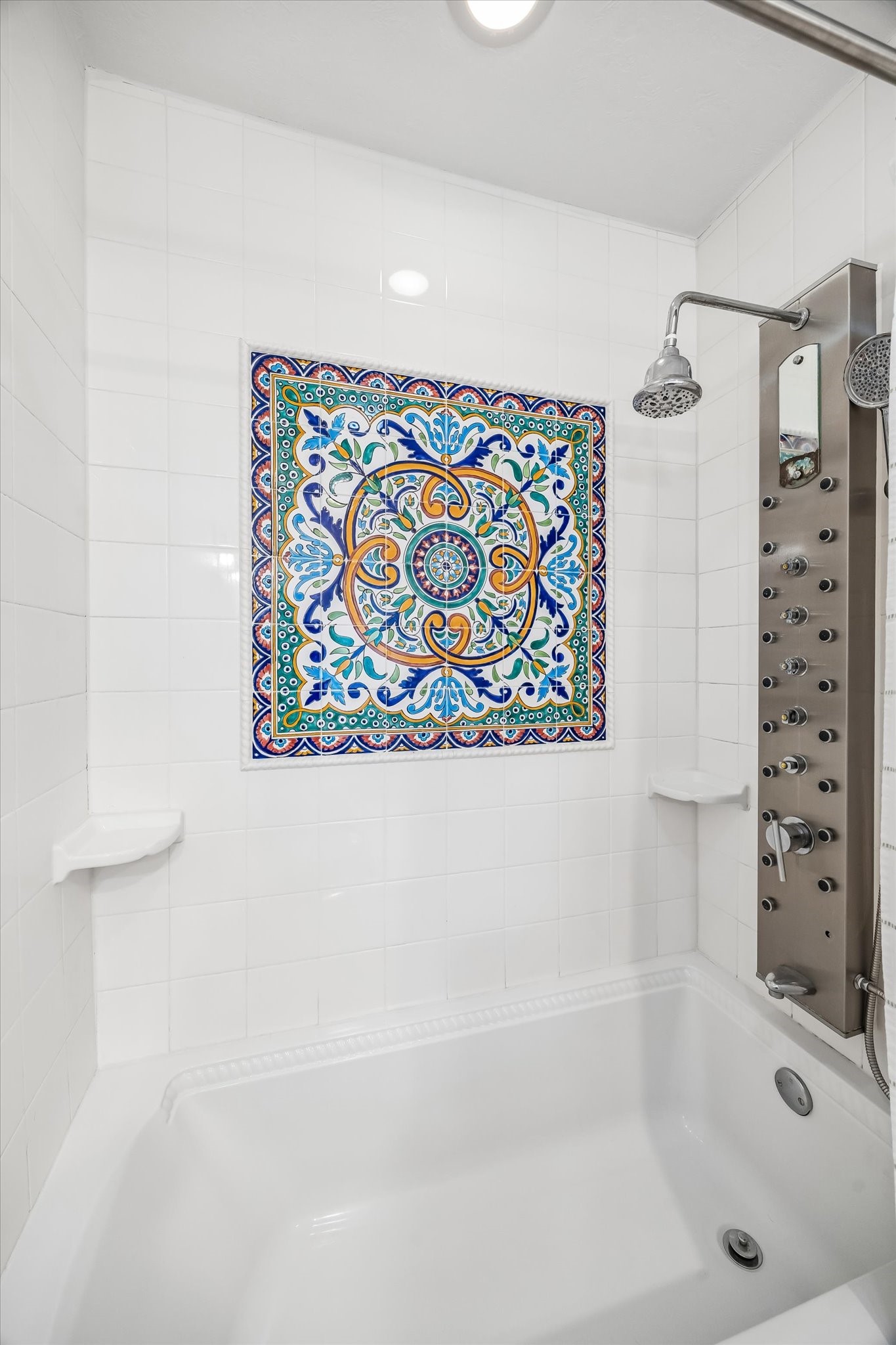 Luxurious shower features a striking decorative tile centerpiece and a modern multi-jet shower panel, creating a spa-like experience.