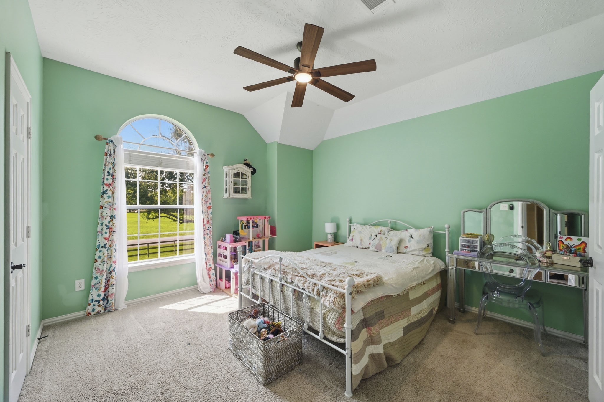 Secondary bedroom with treetop views and convenient Hollywood bath access.