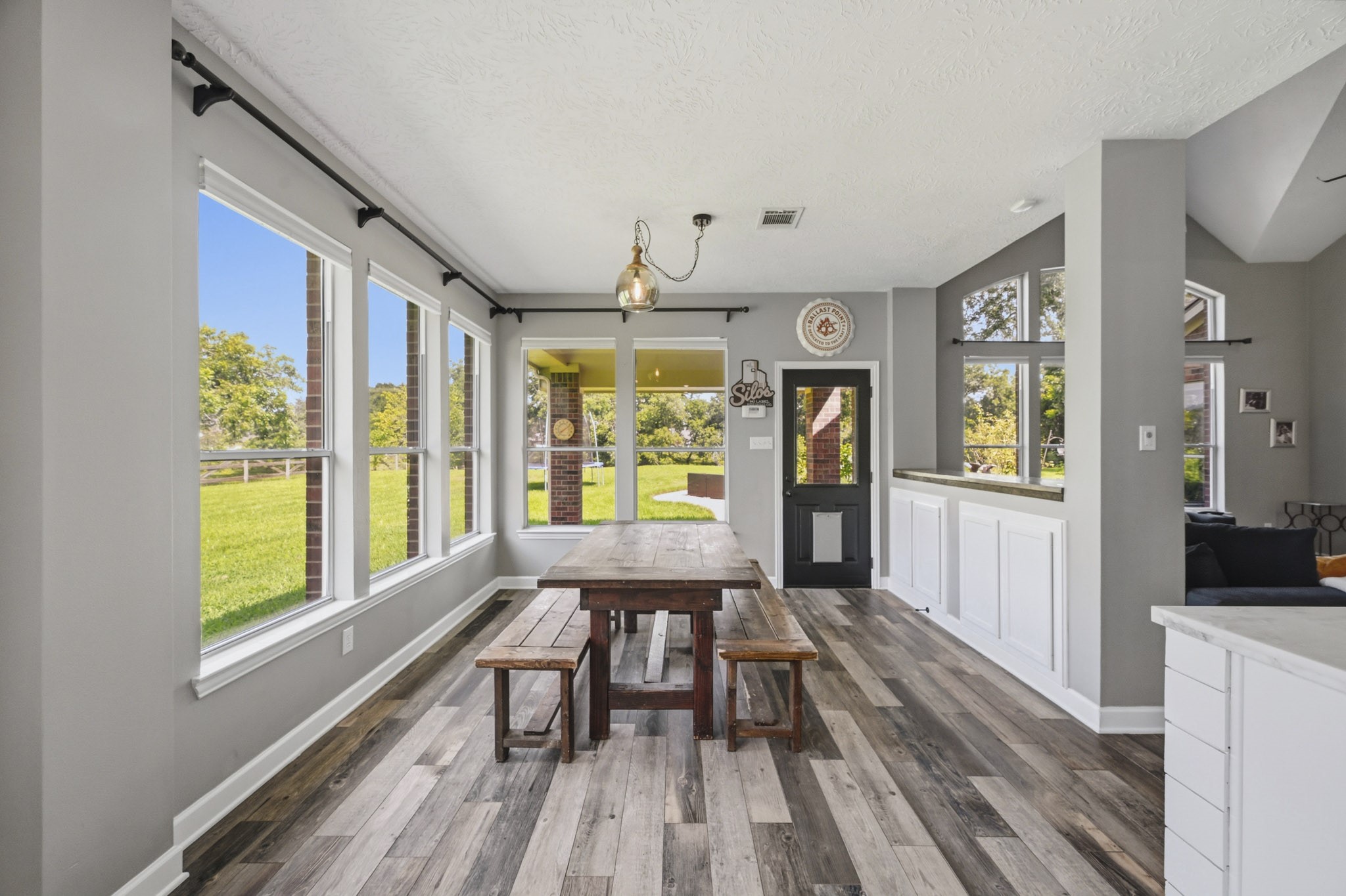 Bright breakfast room with panoramic backyard views, abundant storage, and custom wood countertops.